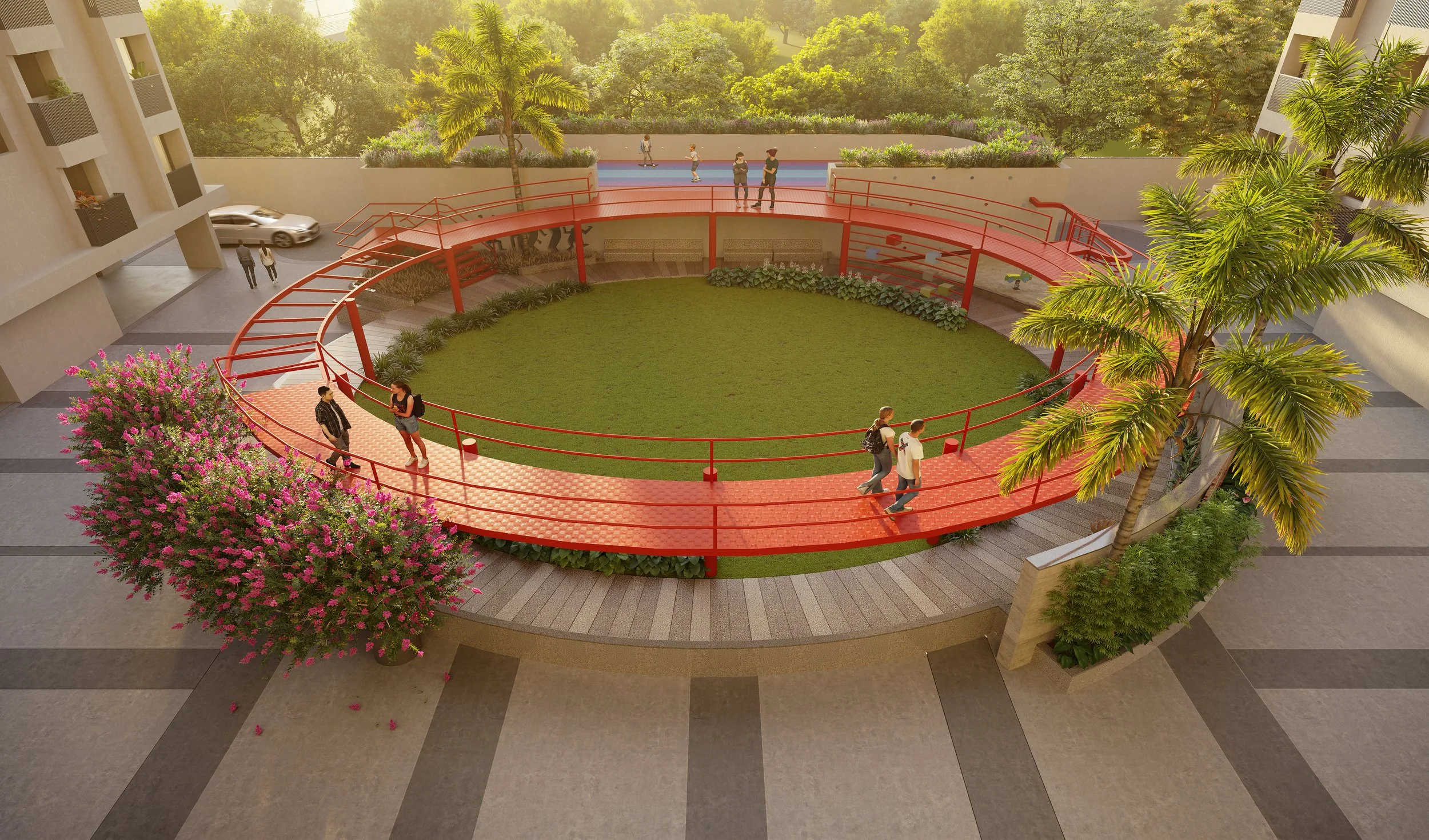 An outdoor circular grassy area surrounded by a red railing and pathway, with a few people walking and talking. There are palm trees and flowering bushes nearby, and in the background, there are trees and a sports court with people playing basketball