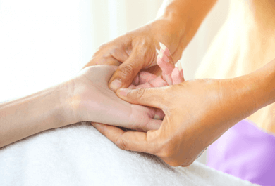 Reflexologist performing calming hand reflexology at New Dawn Holistics in Cumbria