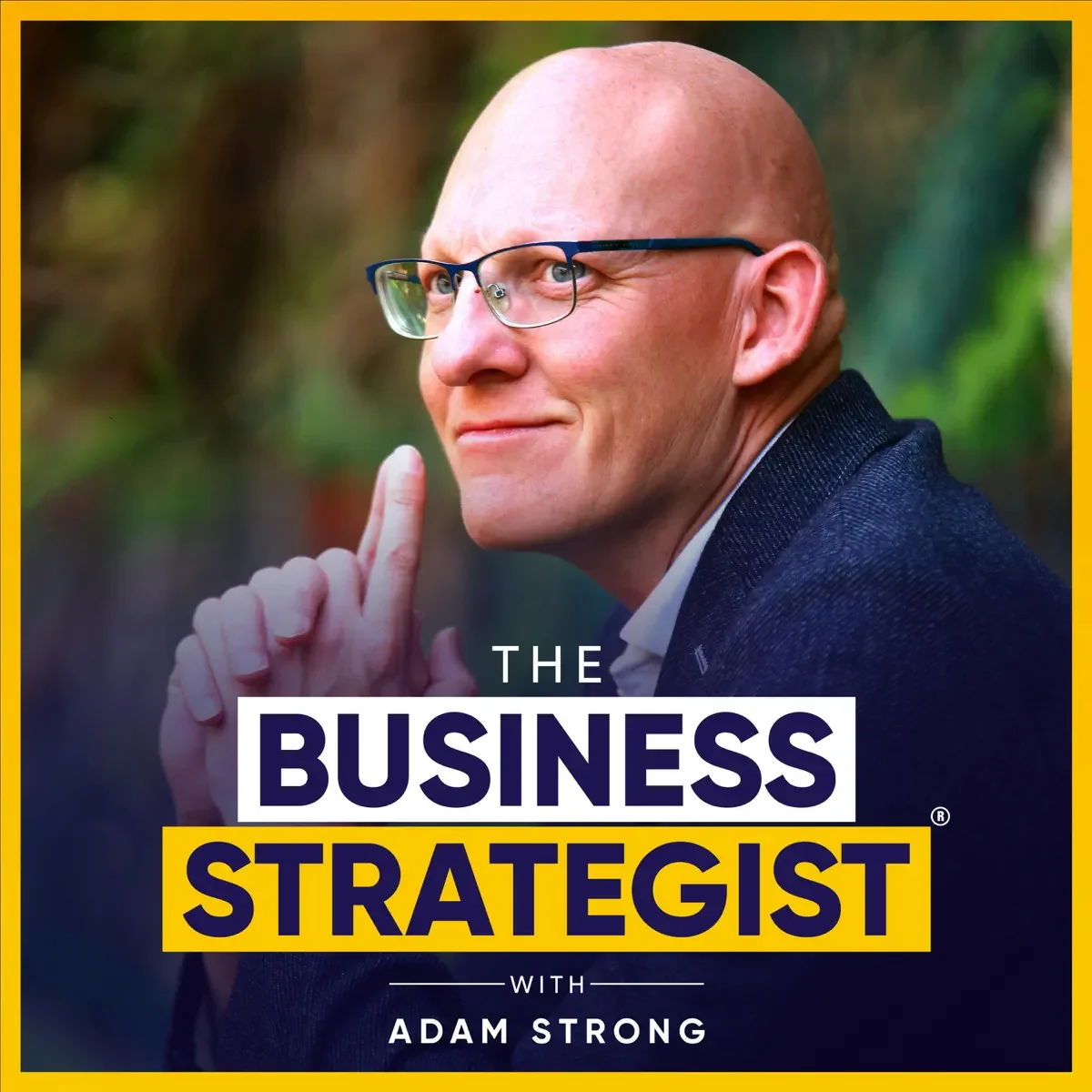 A man with glasses and a bald head smiling and holding his index finger to his lips. The background is blurry with green foliage. Text overlay reads 'The Business Strategist with Adam Strong.'