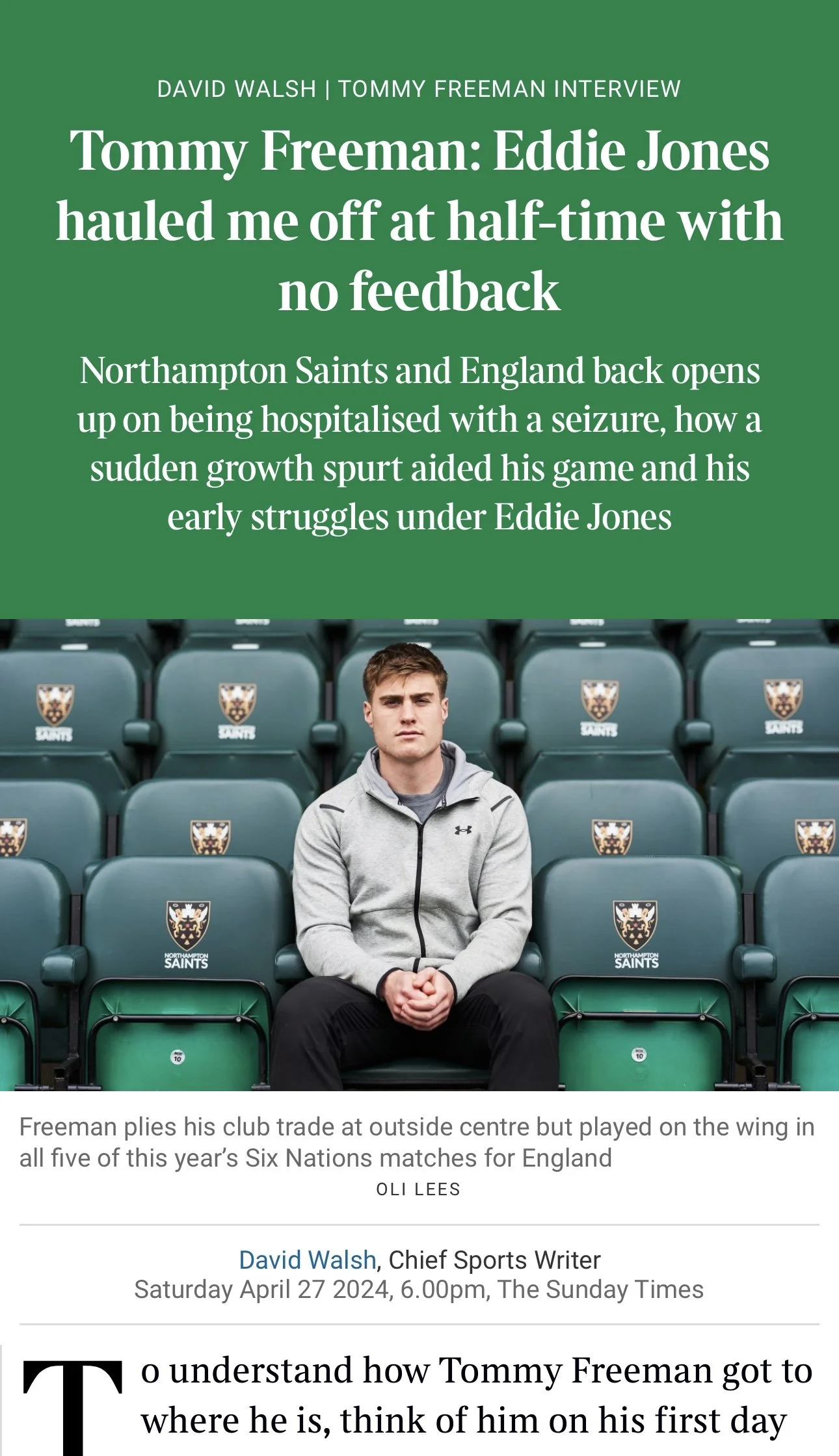 A young man sitting alone in green stadium seats with the Northampton Saints logo. He is wearing a gray jacket and black pants, with a serious expression. The background shows more seats with the team logo. The text discusses an interview about Eddie