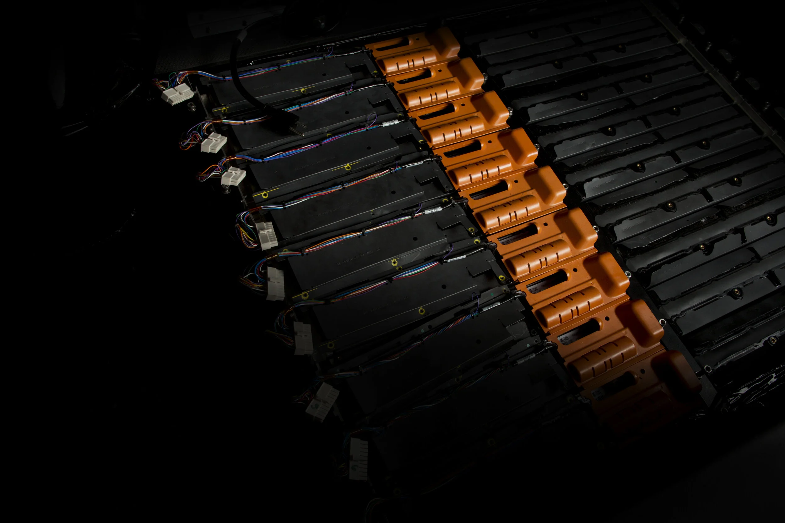 Multiple electric motors and wiring parts laid out in a row on a dark background.