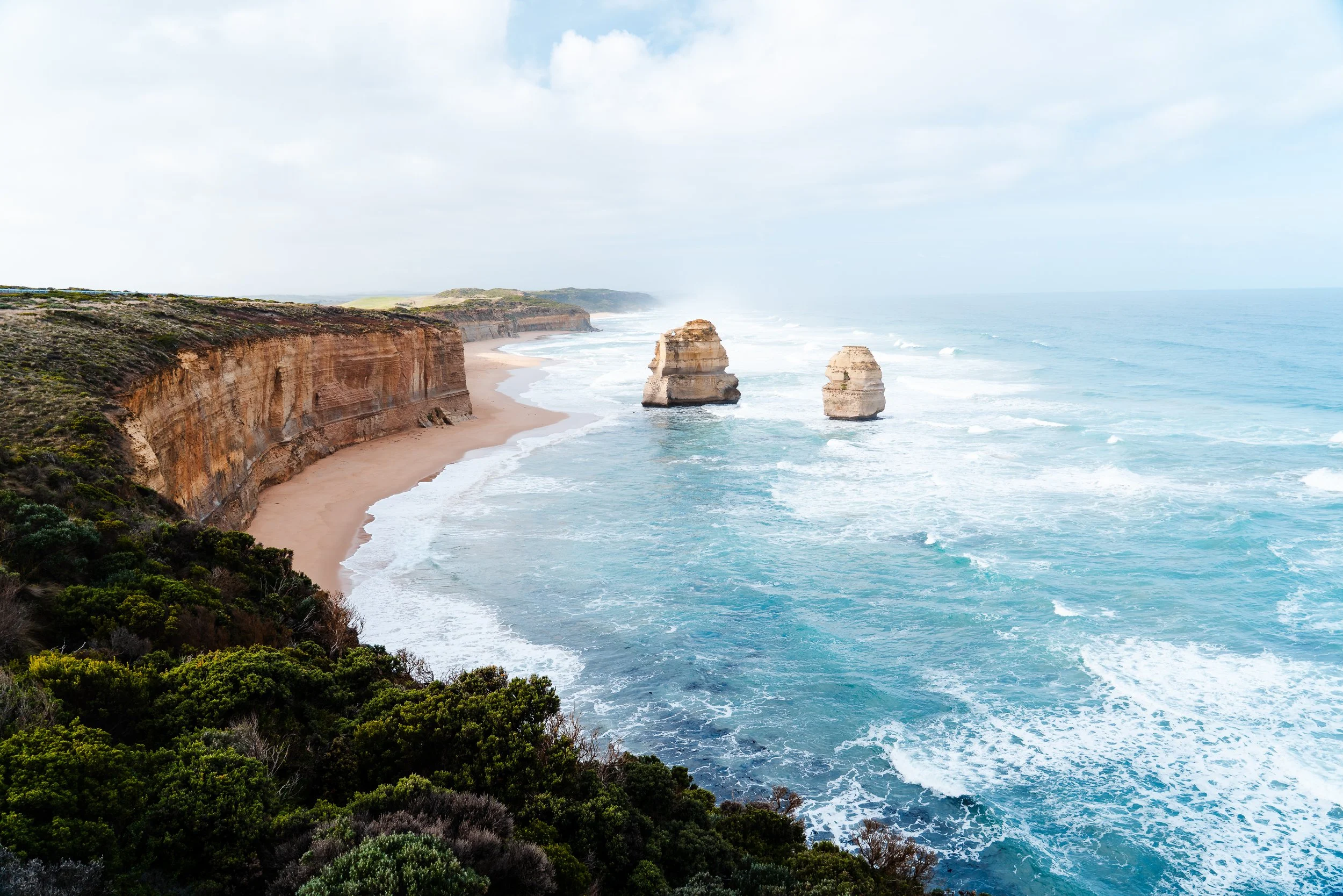 Coastal cliffs with beaches and two large rock formations in the water