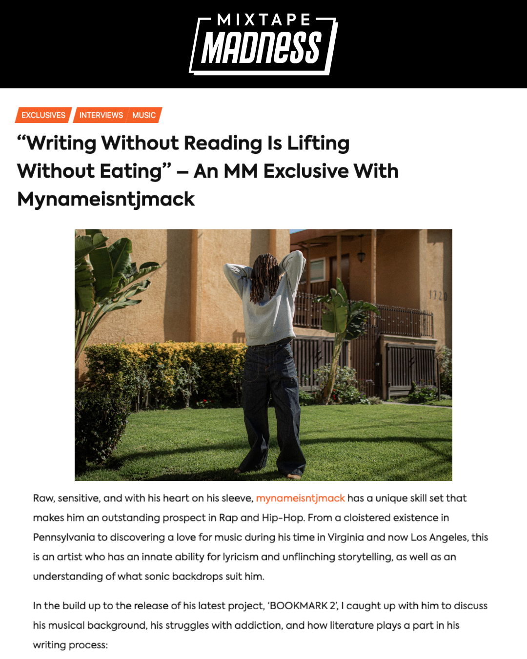 Magazine article webpage with a photo of a person standing outdoors with arms behind head, in front of a beige building and green plants, discussing rapper and lyricist Mynamestnjmack.