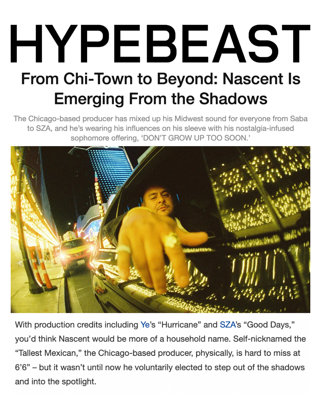 A man with a ring on his middle finger looking out of the side window of a black car, with city lights on a night street reflected on the car's surface.