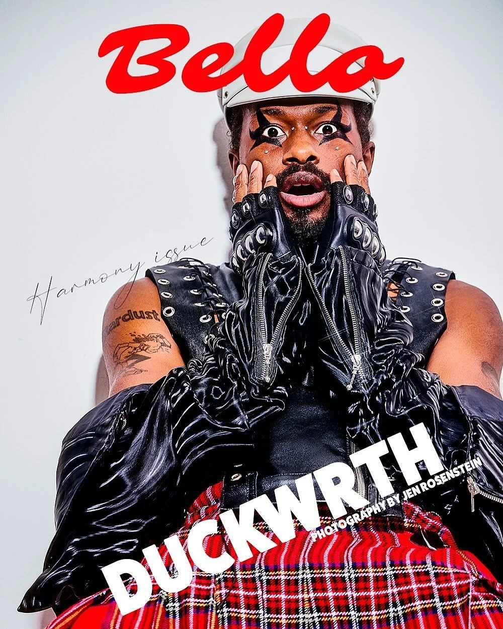 Cover of Bella magazine featuring a person with artistic makeup, wearing leather gloves and a leather vest, with a red plaid skirt, and the title 'Duckwrth' and 'Harmony issue' by Jen Rosenstein.