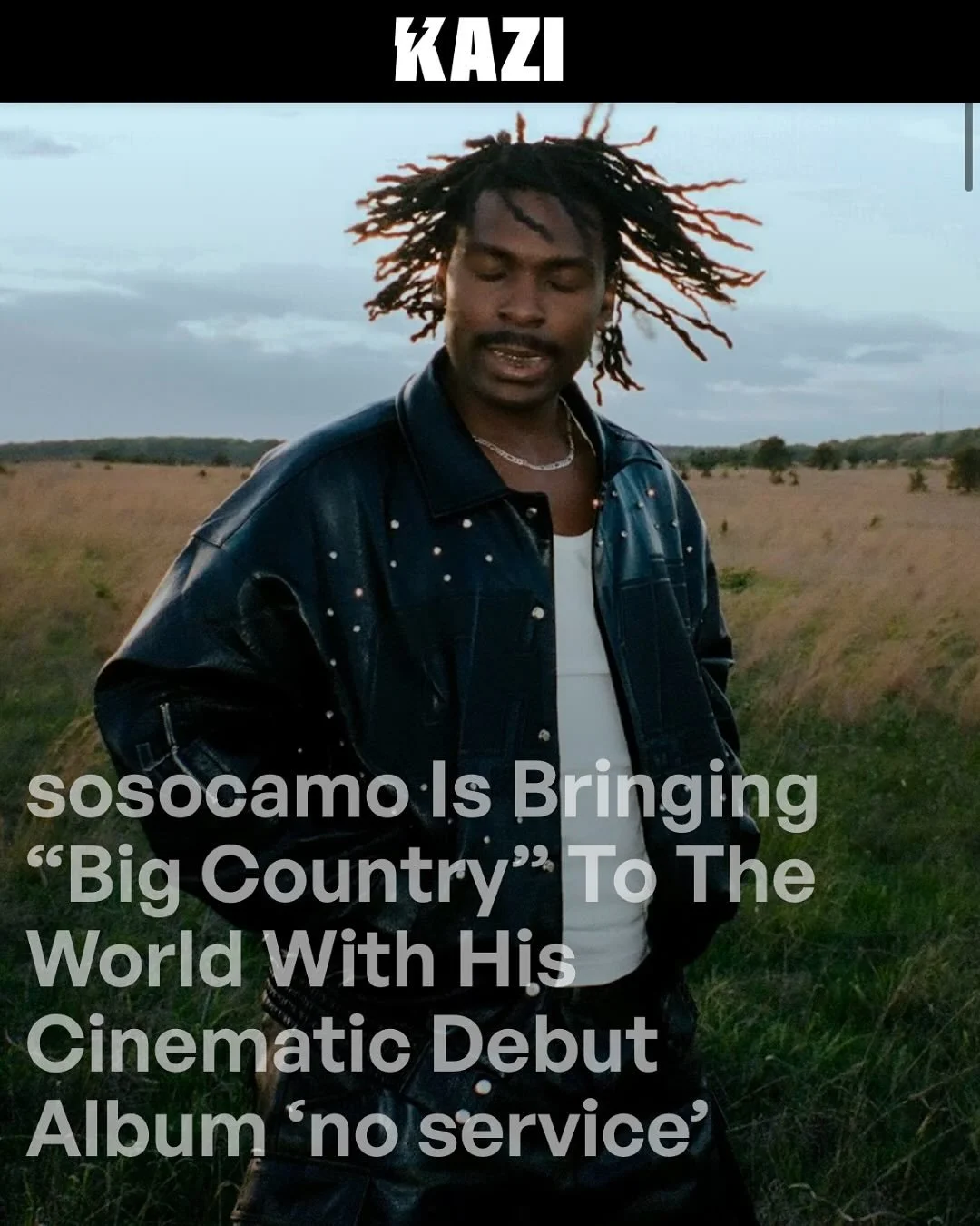 A man with dreadlocks wearing a black leather jacket with white dots, standing outdoors in a field under a cloudy sky, with overlaid text about sosocamo's cinematic debut album.