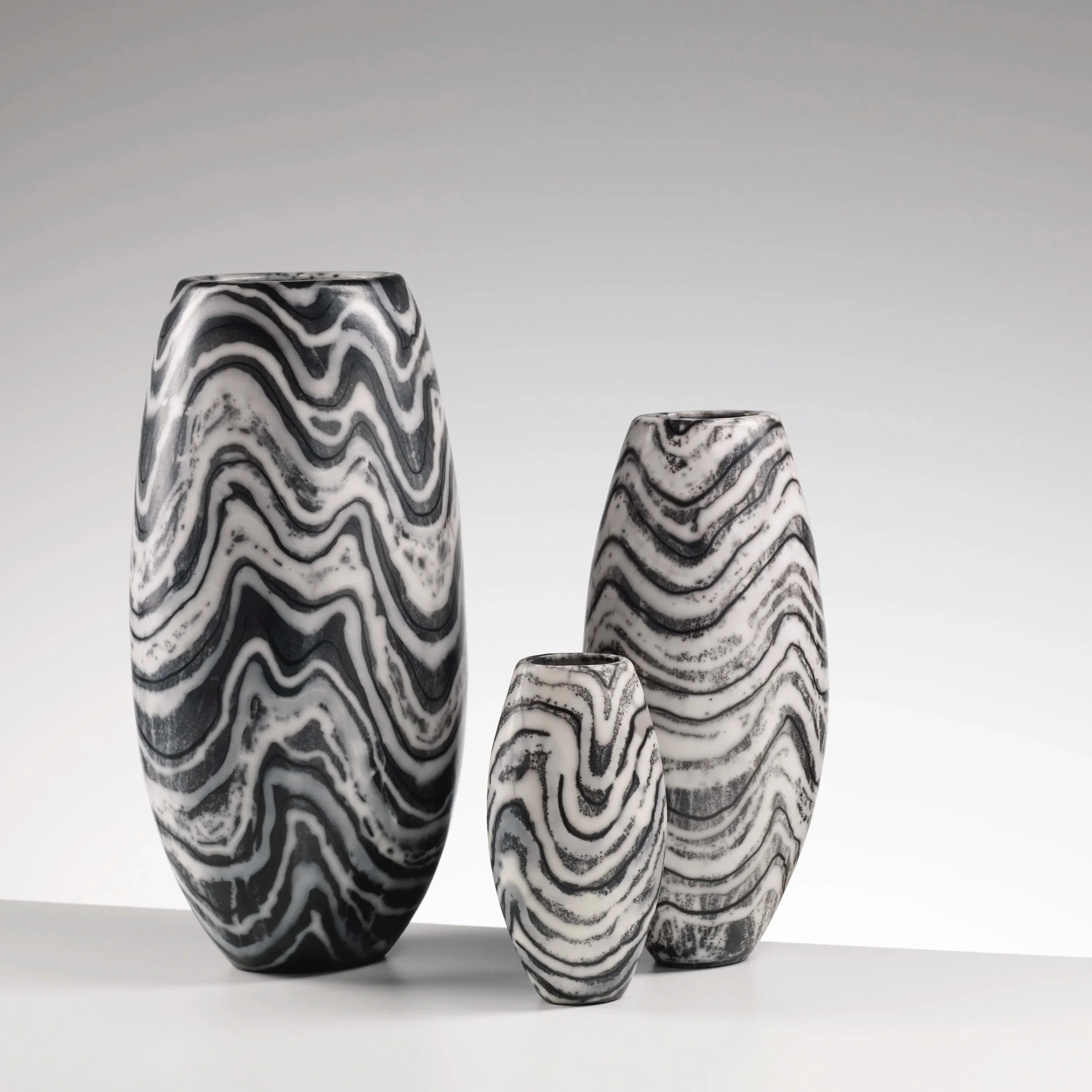 large, medium and small Lewisian Gneiss vases in black and white naked raku ceramic by Moyra Stewart