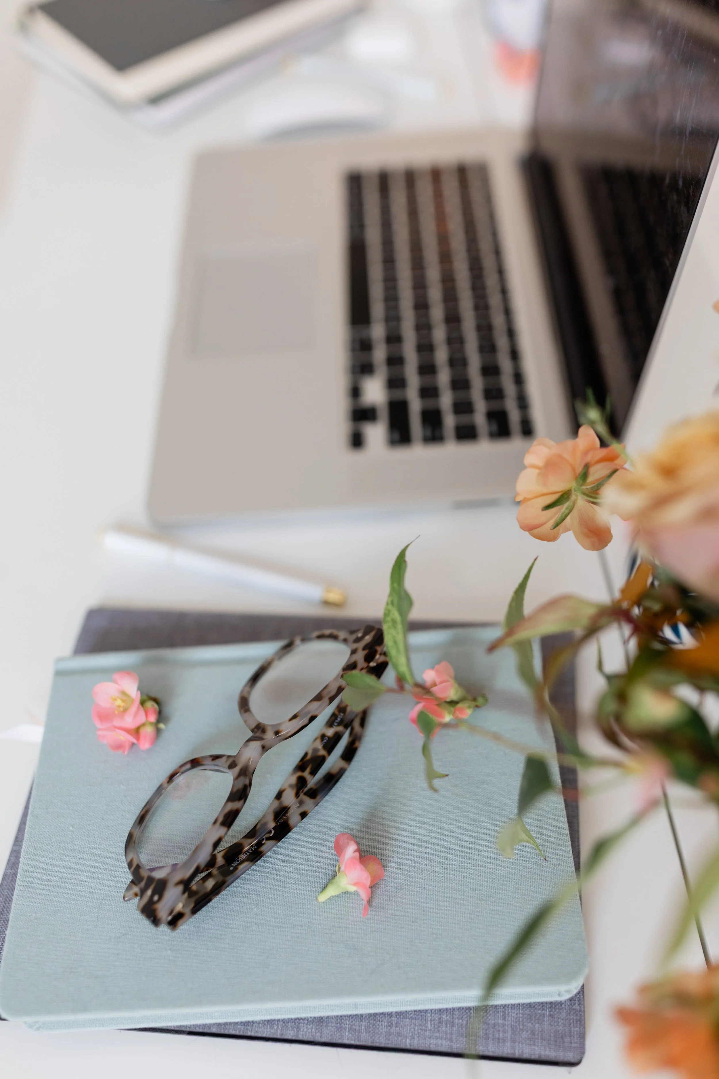 Minimal workspace with notebook and pen, reflecting intentional, unhurried work.
