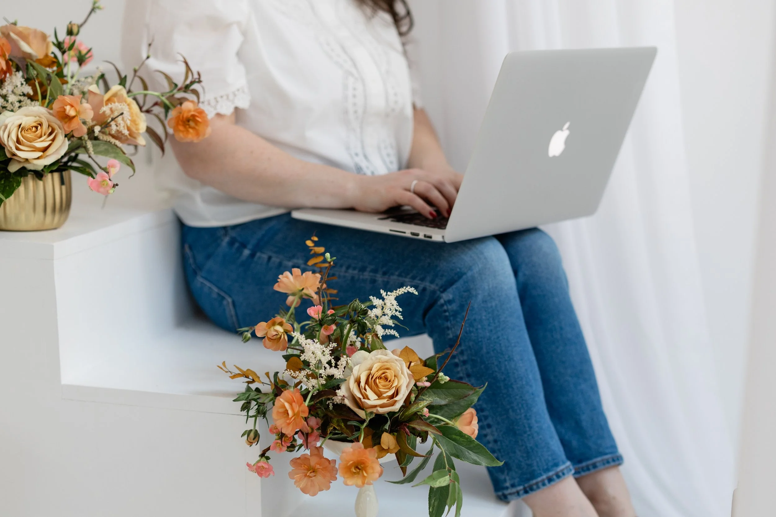 Briana Wells seated at a laptop, writing reflective essays for The Margin archive.