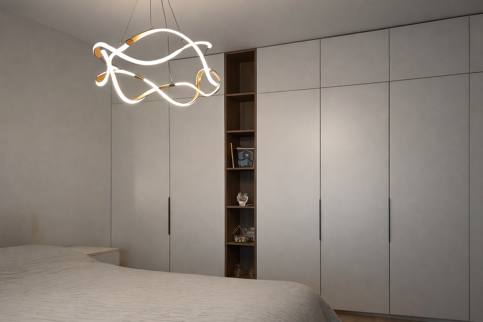 Modern bedroom with a bed, white wardrobe, a wooden shelving unit with decorative items, and a contemporary hanging ceiling light.