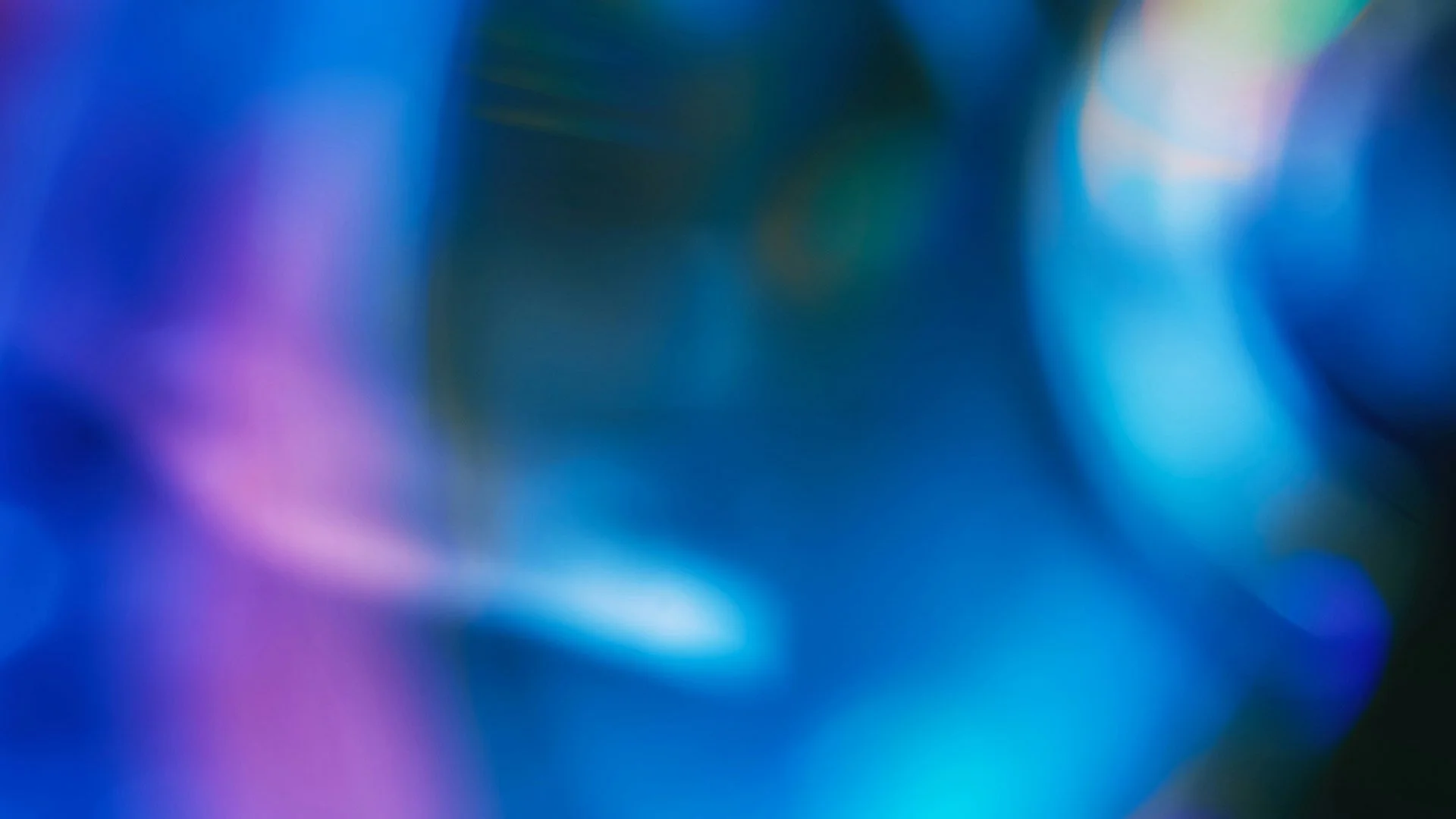 Blurred abstract background with shades of blue, purple, and green.