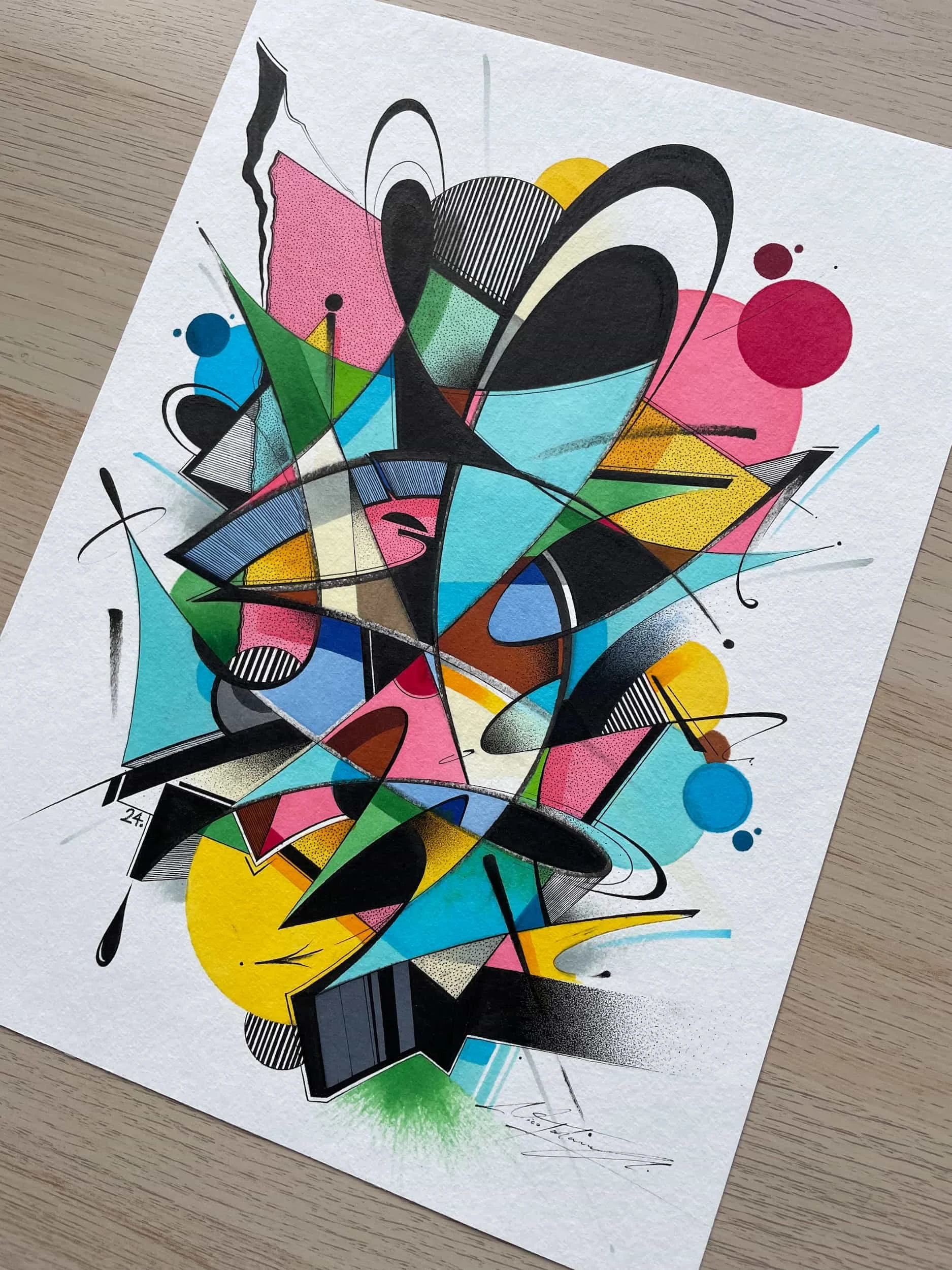 Abstract graffiti art with bold black outlines, colorful shapes in pink, blue, yellow, green, and black, including circles, triangles, and lines on textured white paper.