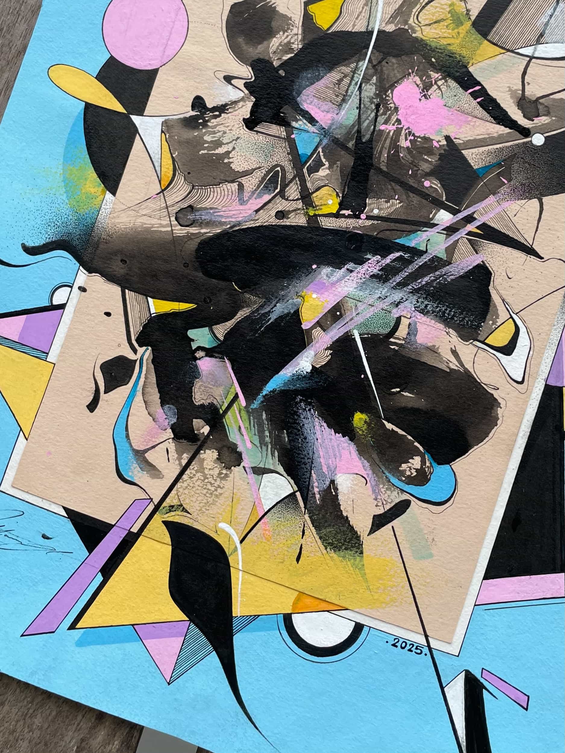 Abstract geometric artwork with splashes of black, pink, blue, yellow, and purple paint on layered paper, including triangles, circles, and lines, with the year 2025 visible.