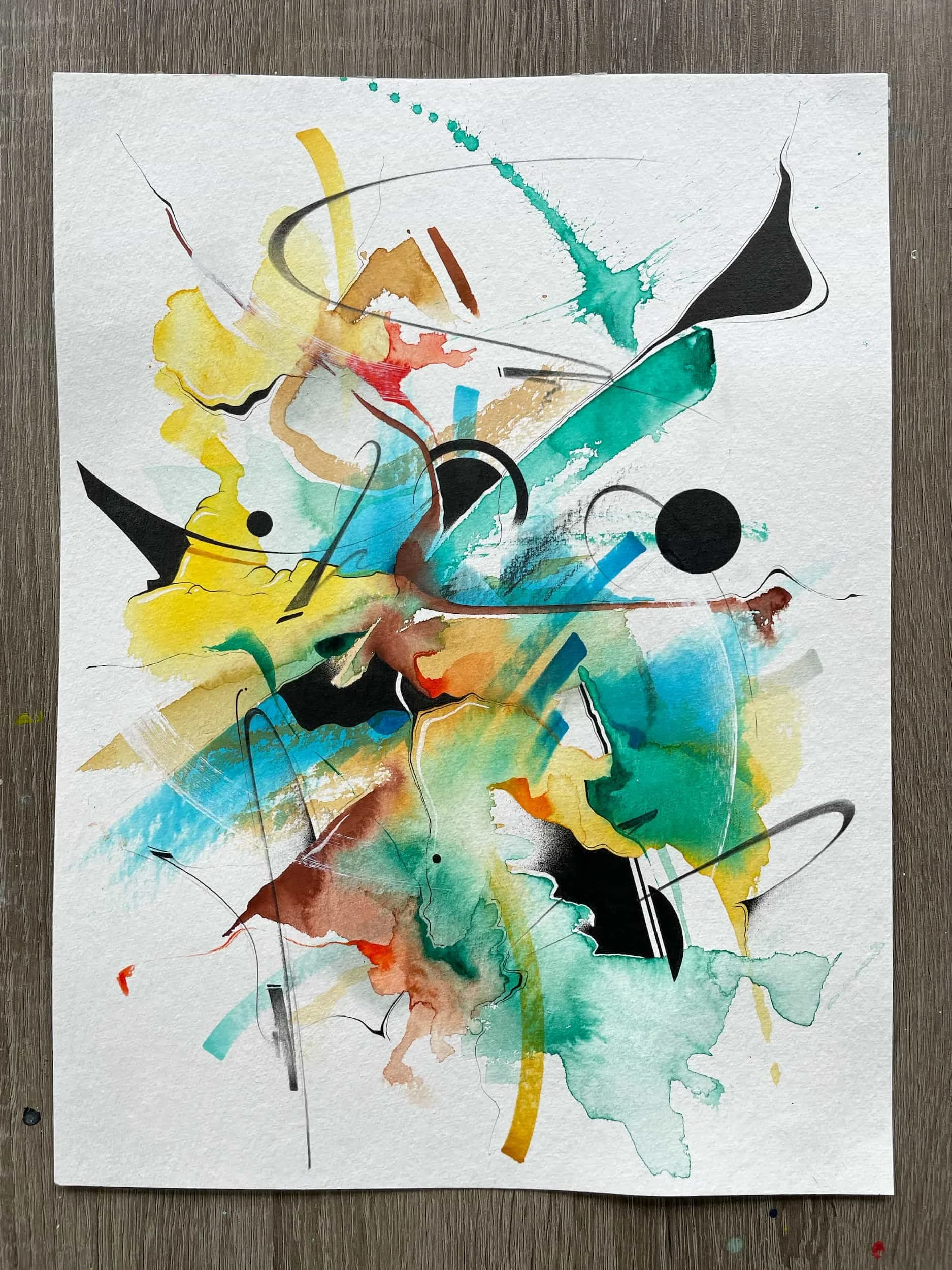 Abstract watercolor painting with splashes of yellow, blue, green, red, black, and brown, featuring curved lines and circular shapes on textured paper.