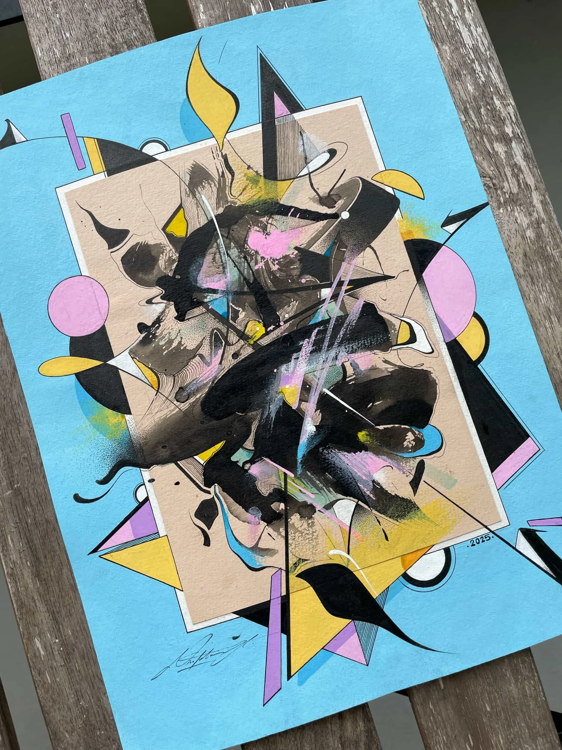 Abstract mixed media artwork on blue paper with geometric shapes, splatters, and organic forms, signed and dated 2025.