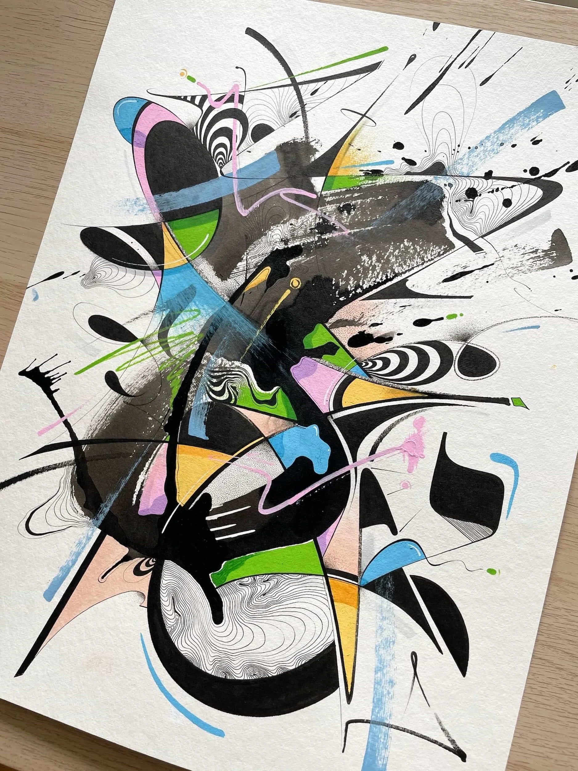 Abstract graffiti art with black, white, green, yellow, pink, blue, and purple colors on a white paper background, featuring various lines, shapes, and patterns.