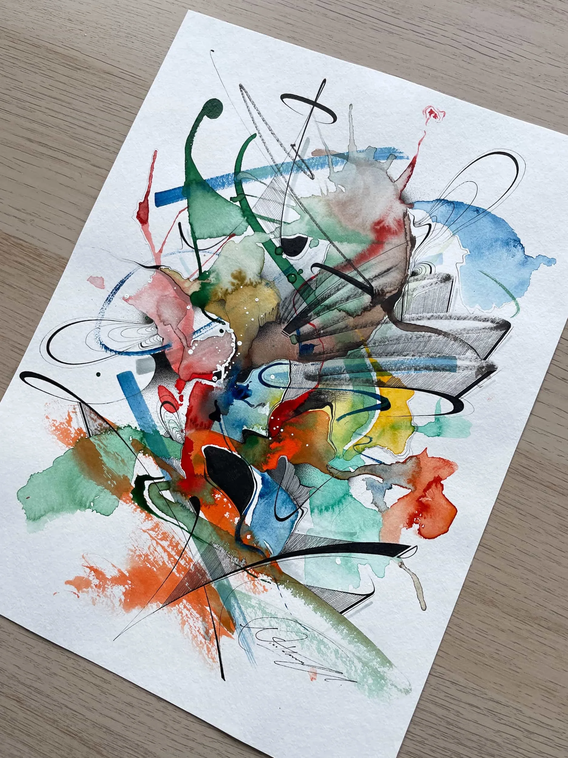 Abstract watercolor painting on paper featuring splashes of red, orange, yellow, green, blue, brown, and black, with various lines and strokes.