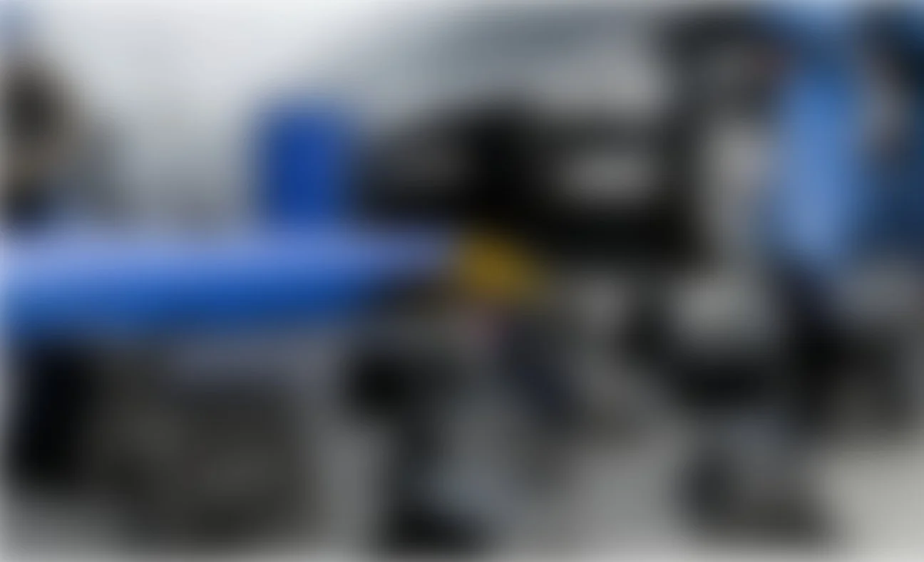 Das Bild ist stark verschwommen, es ist schwierig, die genauen Gegenstände zu erkennen, aber es scheint sich um eine Werkstatt oder einen Maschinenraum mit mehreren Werkzeugen und Maschinen zu handeln.