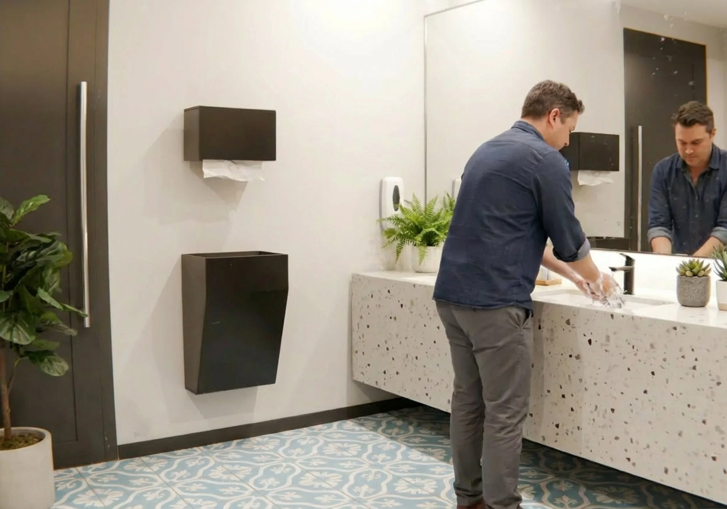 Papermate – paperM8 smarter Papierhandtuchspender im Einsatz: Person nutzt berührungslosen Spender in modernem Badezimmer mit gemustertem Fliesenboden