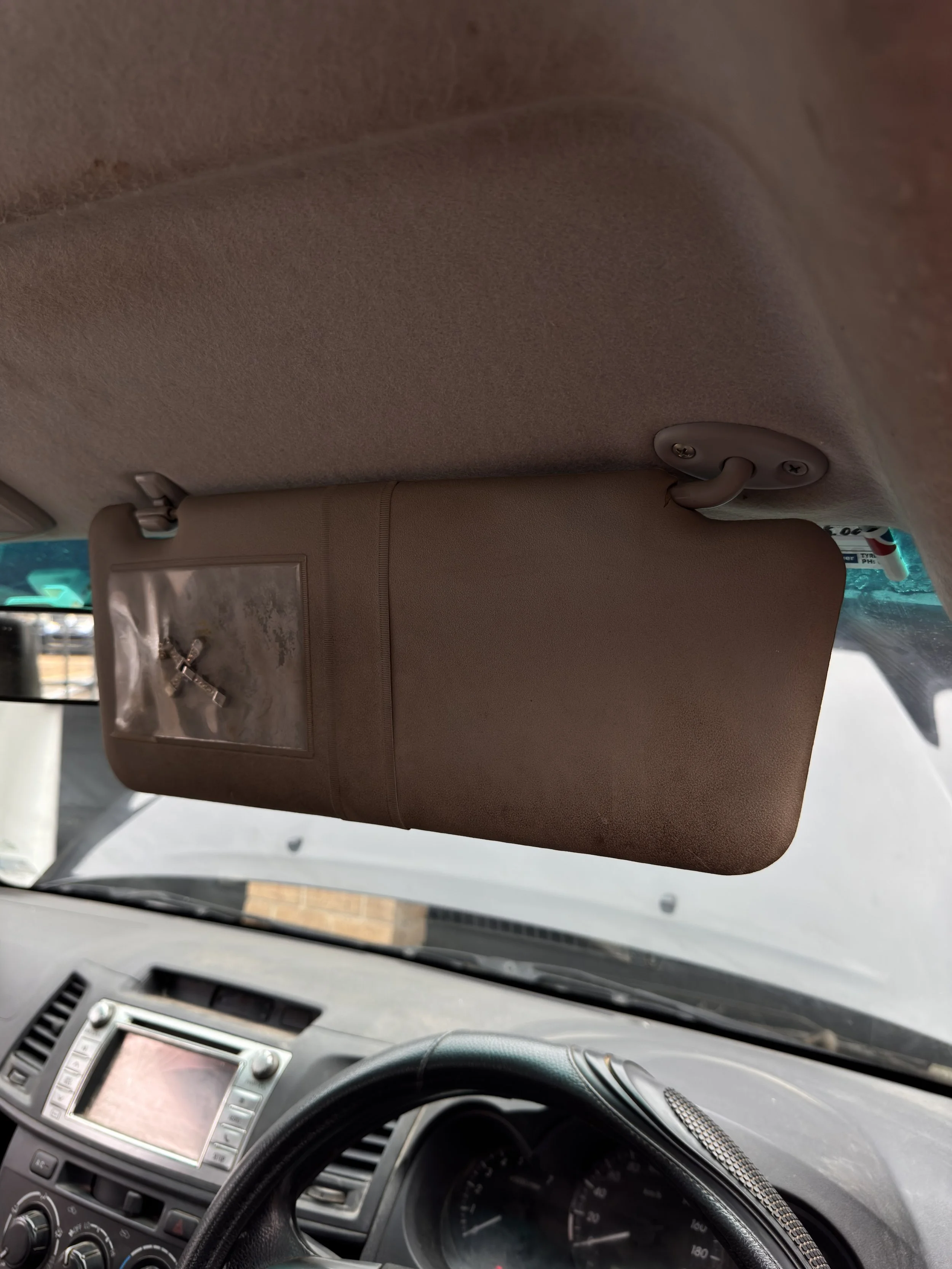 View of a car's interior showing the sun visor and dashboard.