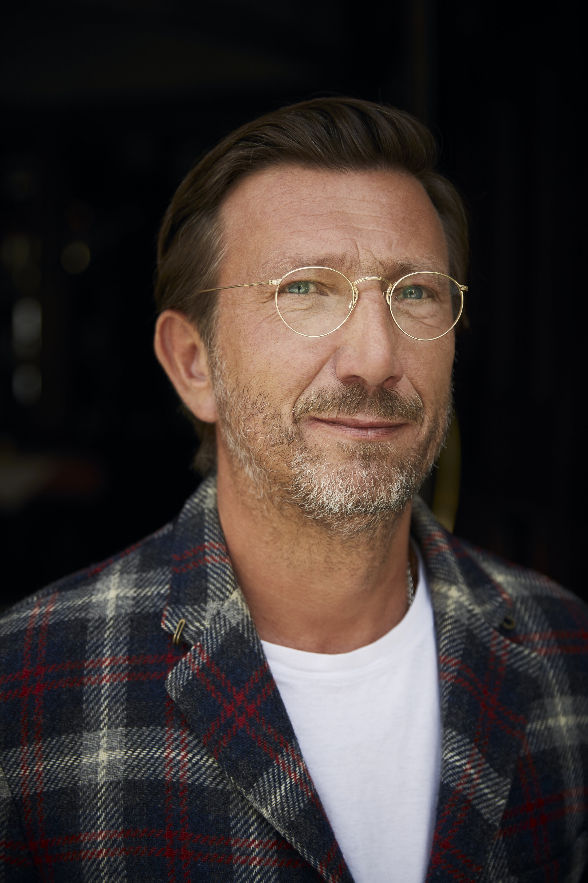 Porträt eines Mannes mit Brille und Karohemd.