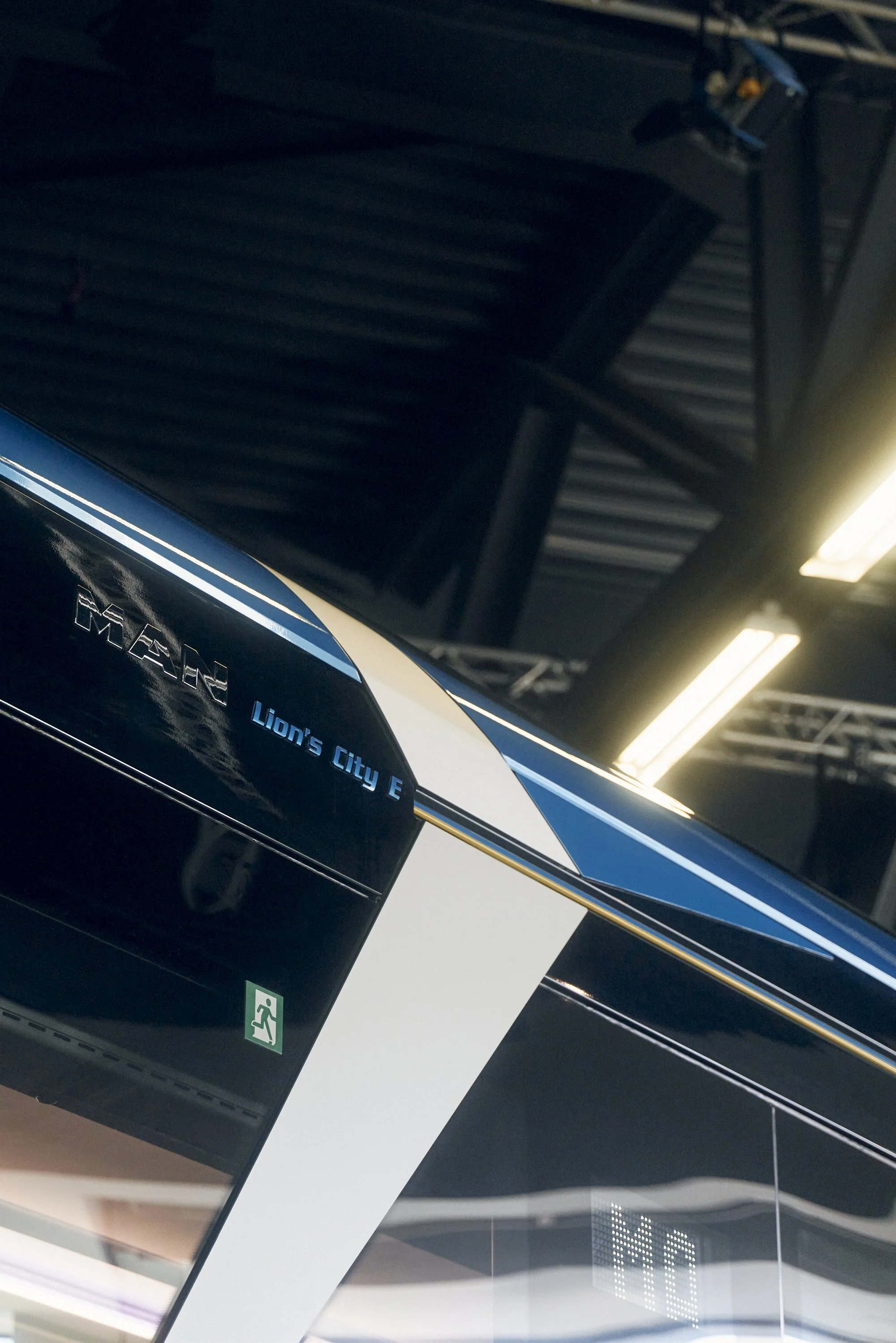 Detailaufnahme eines MAN Lion's City E-Busses mit Logo und Beschriftung.