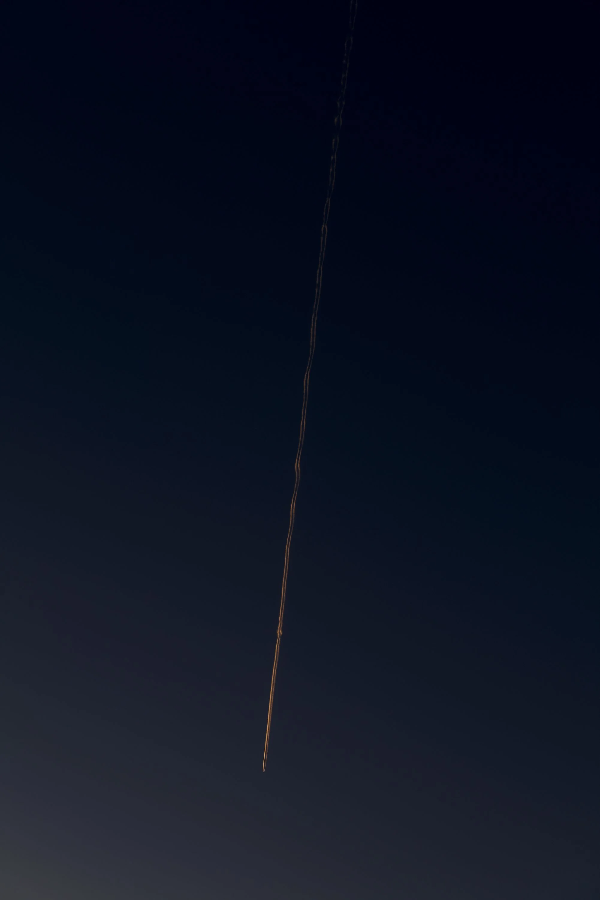 Rauchspur eines Raketenstarts am Nachthimmel.