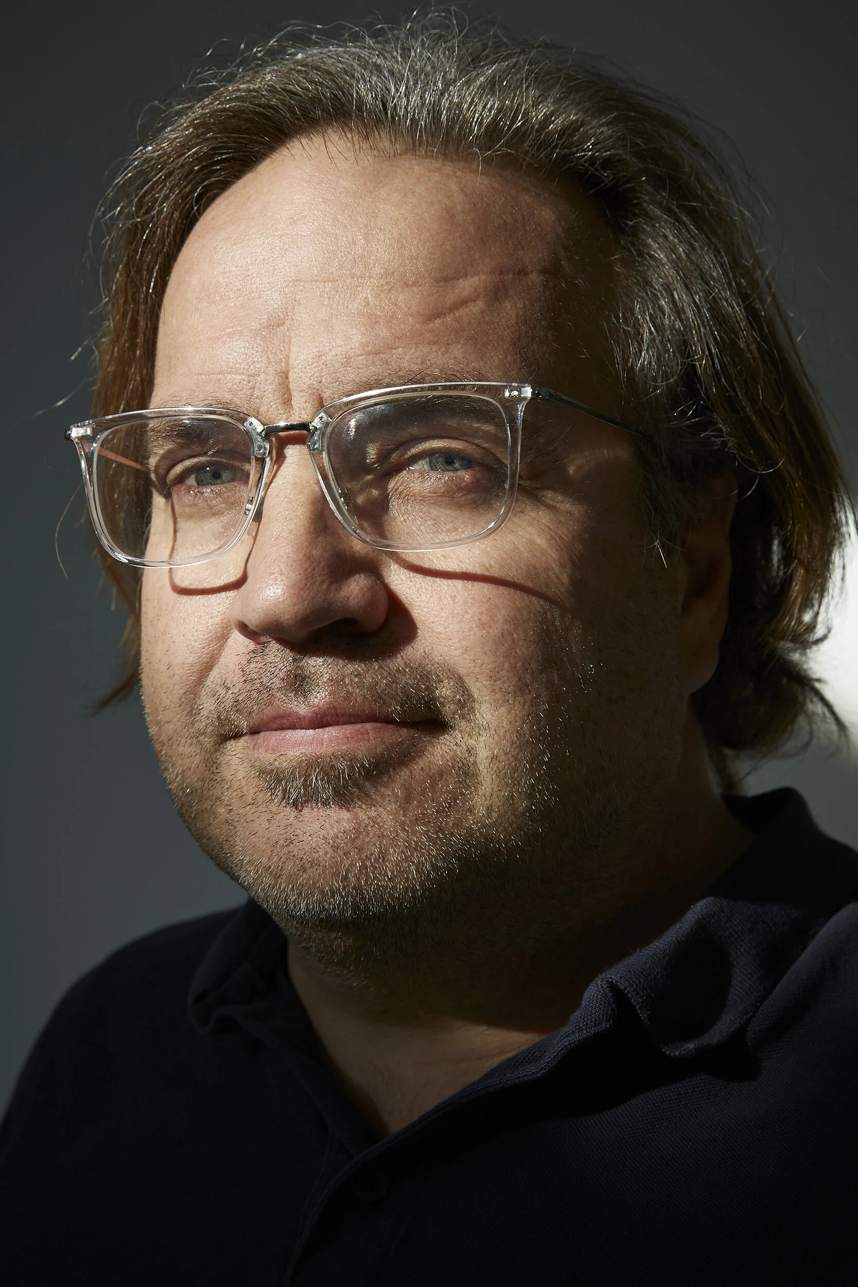 Nahaufnahme eines Mannes mit Brille, braunem Haar und Bart.