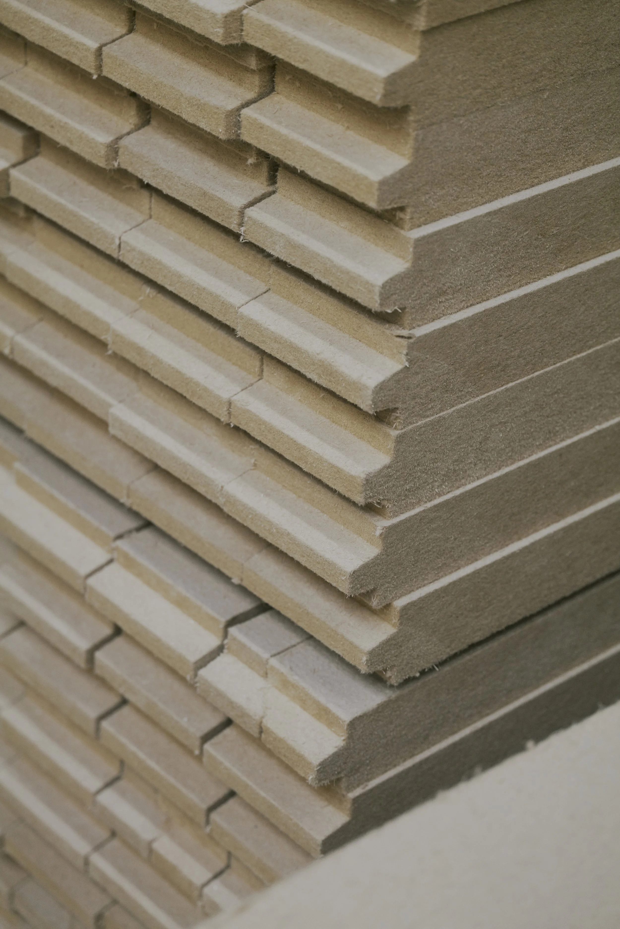 Gestapelte Holzplatten mit profilierter Oberfläche in einem Lager.