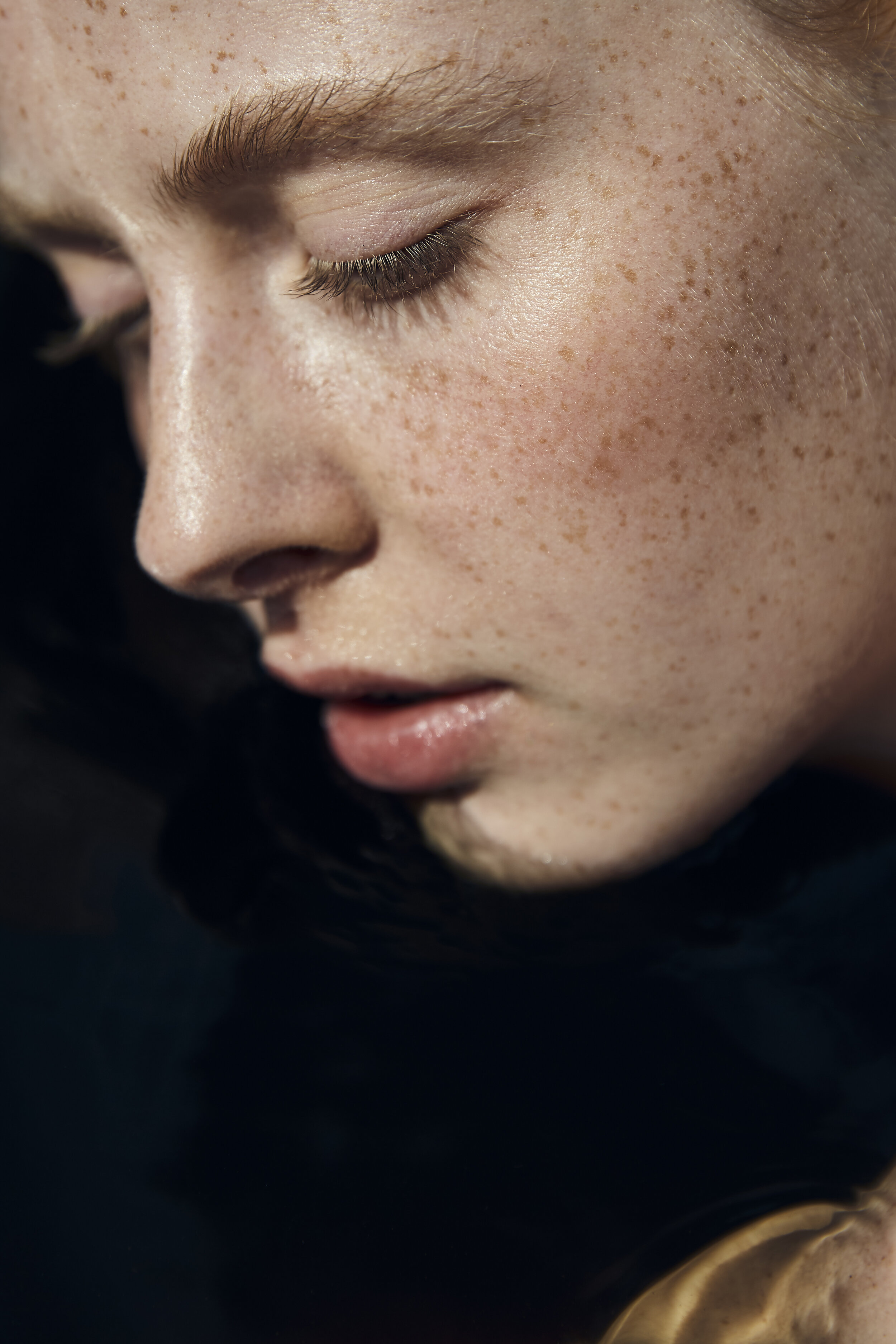 Nahaufnahme eines Gesichts mit Sommersprossen.