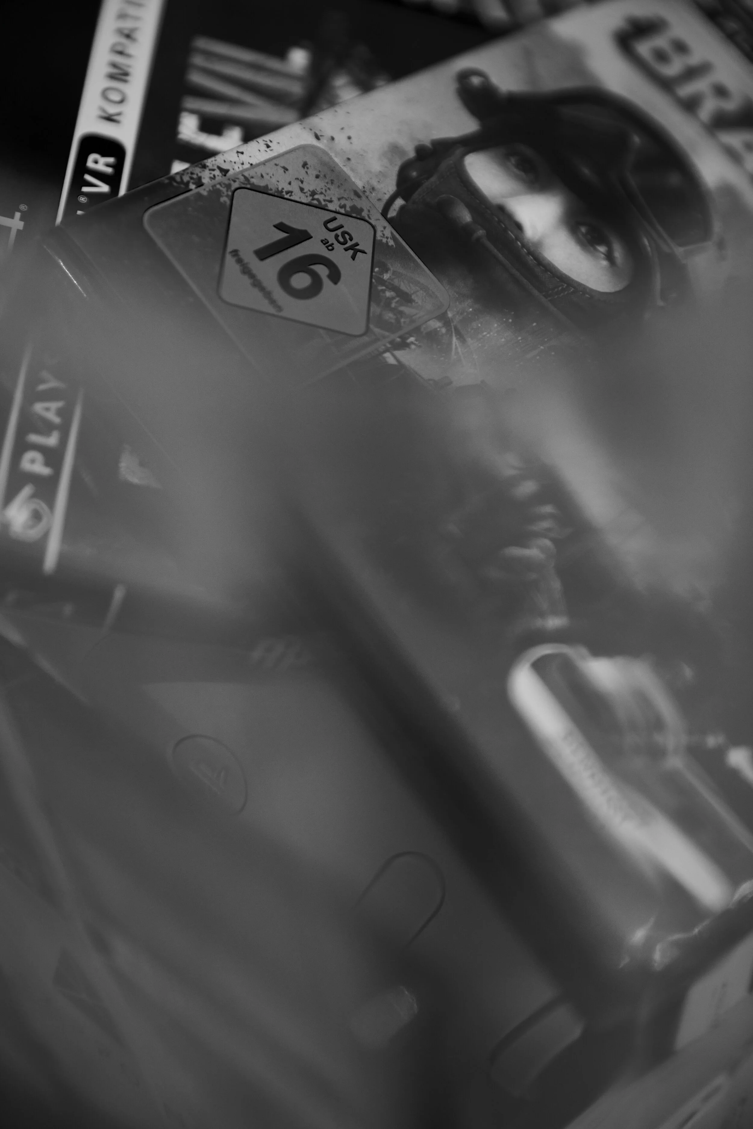 Nahaufnahme von Schwarz-Weiß-Videospielverpackungen mit einem USK-16-Alterseinstufungssymbol.