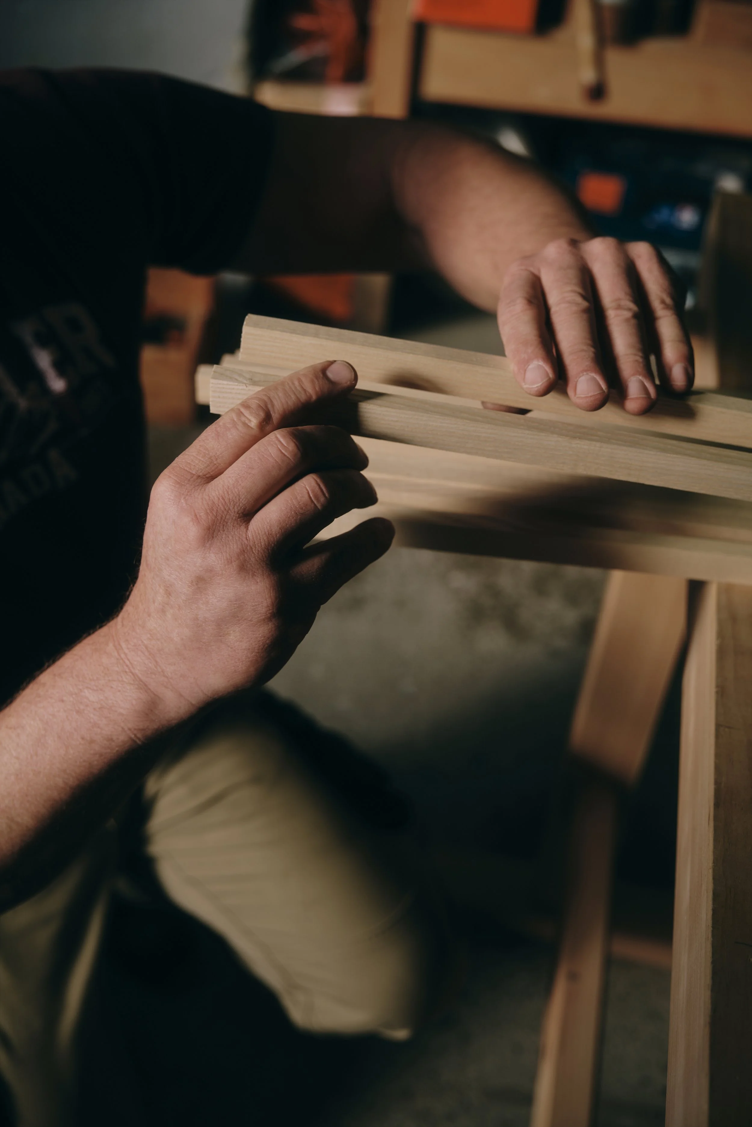Handwerker, der ein Stück Holz in einer Werkstatt bearbeitet.