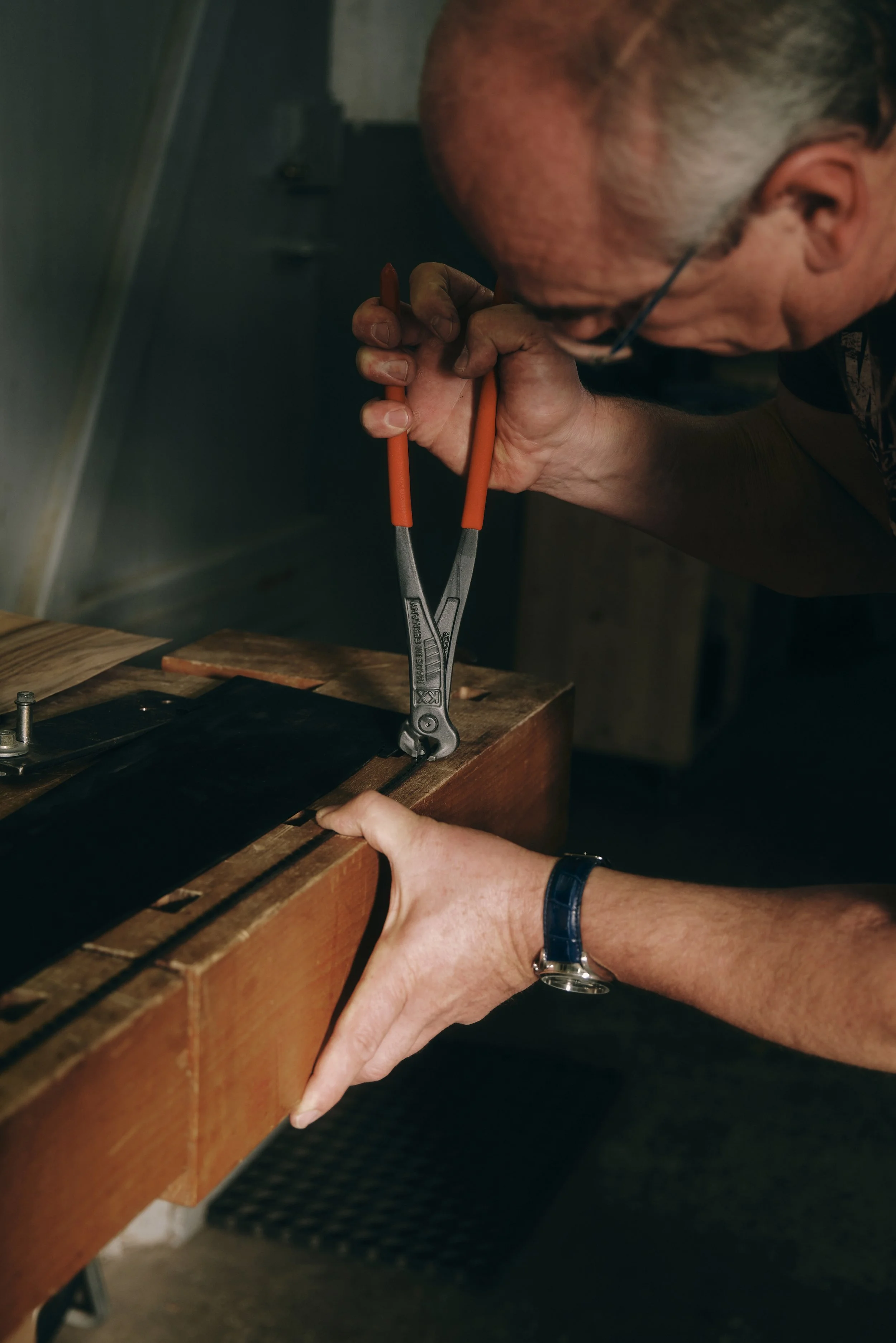 Mann verwendet Zange an der Werkbank