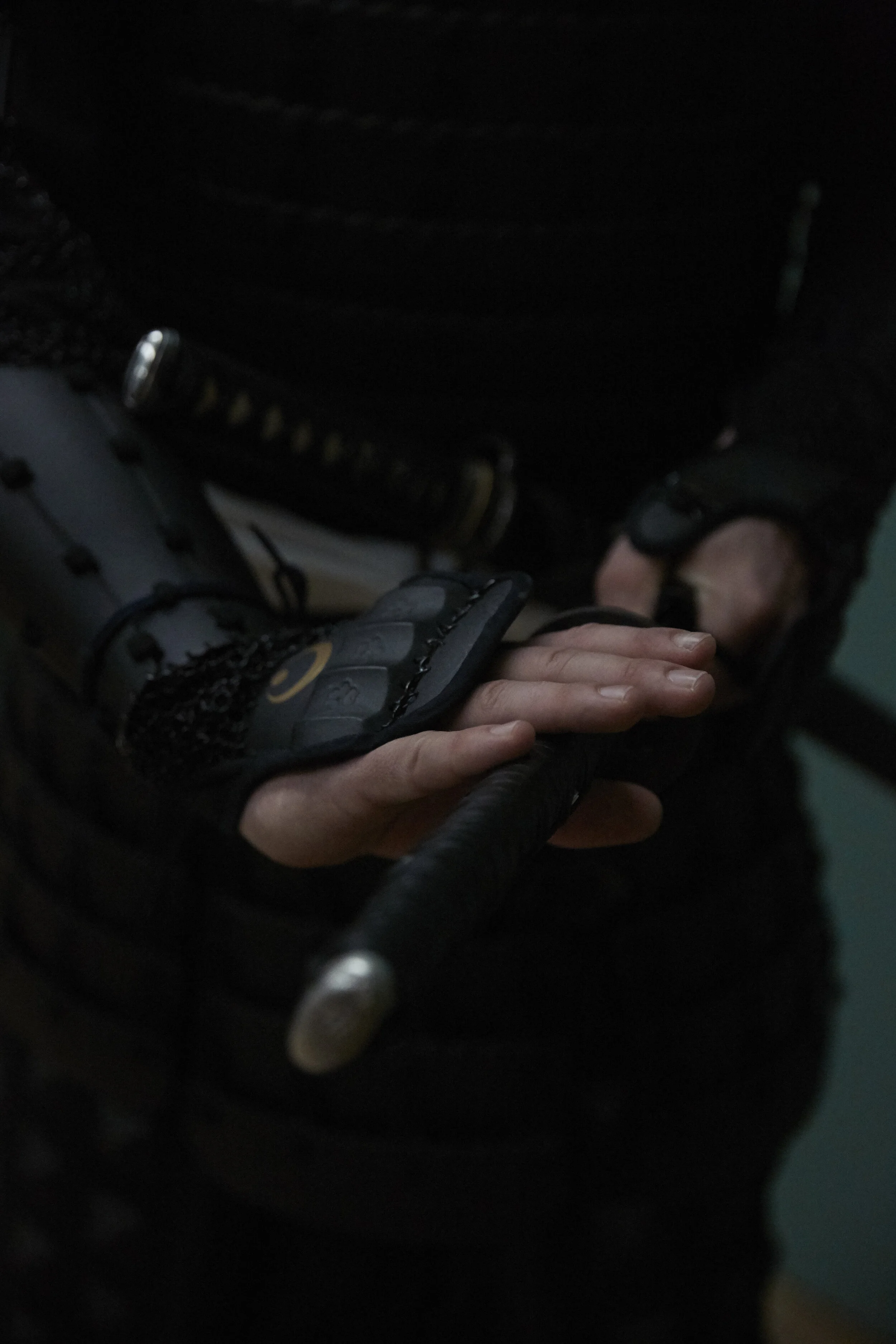 Person in traditioneller Rüstung hält Schwertgriff