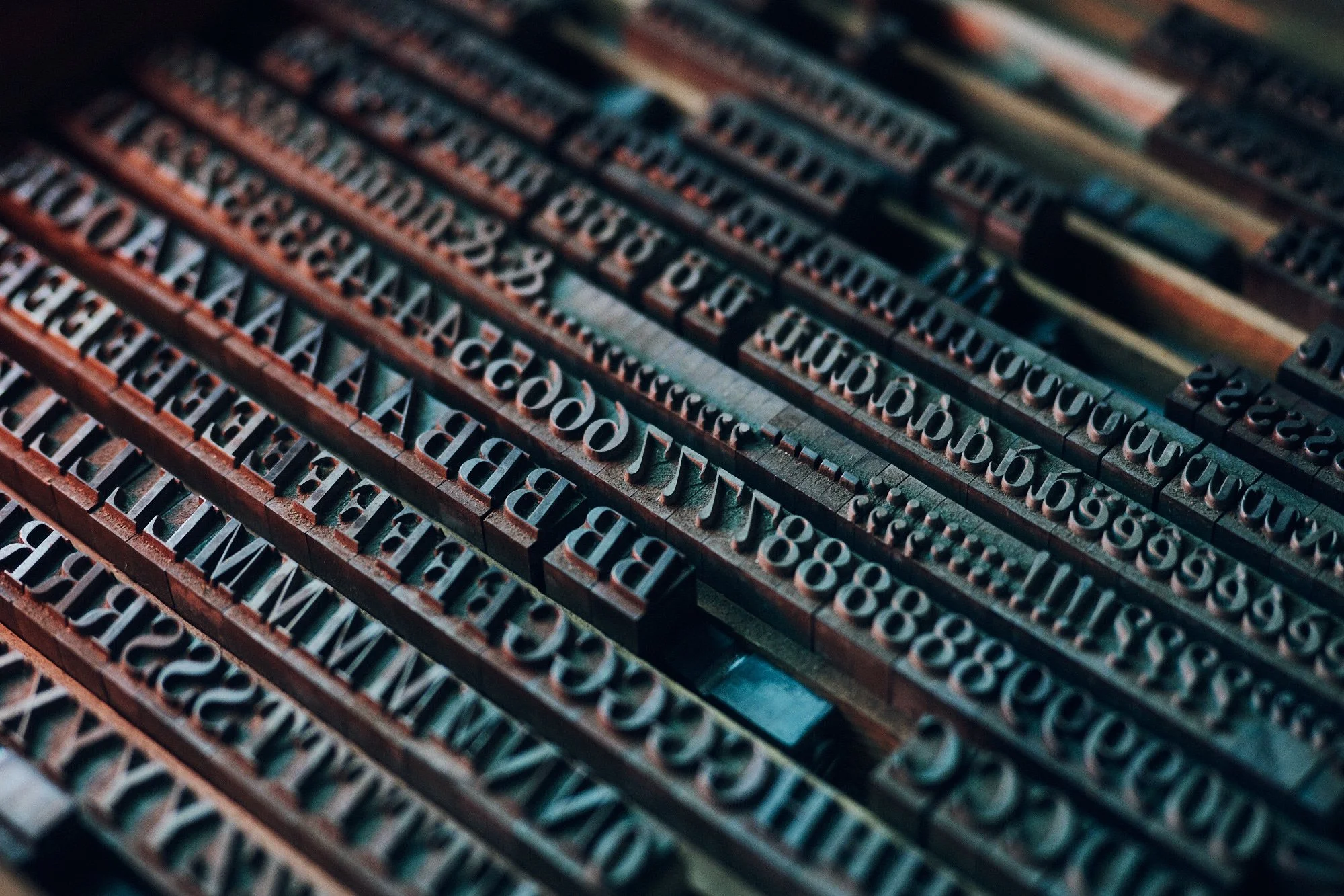 Nahaufnahme von Holzbuchstaben und Zahlen in einem traditionellen Setz- und Drucksystem.