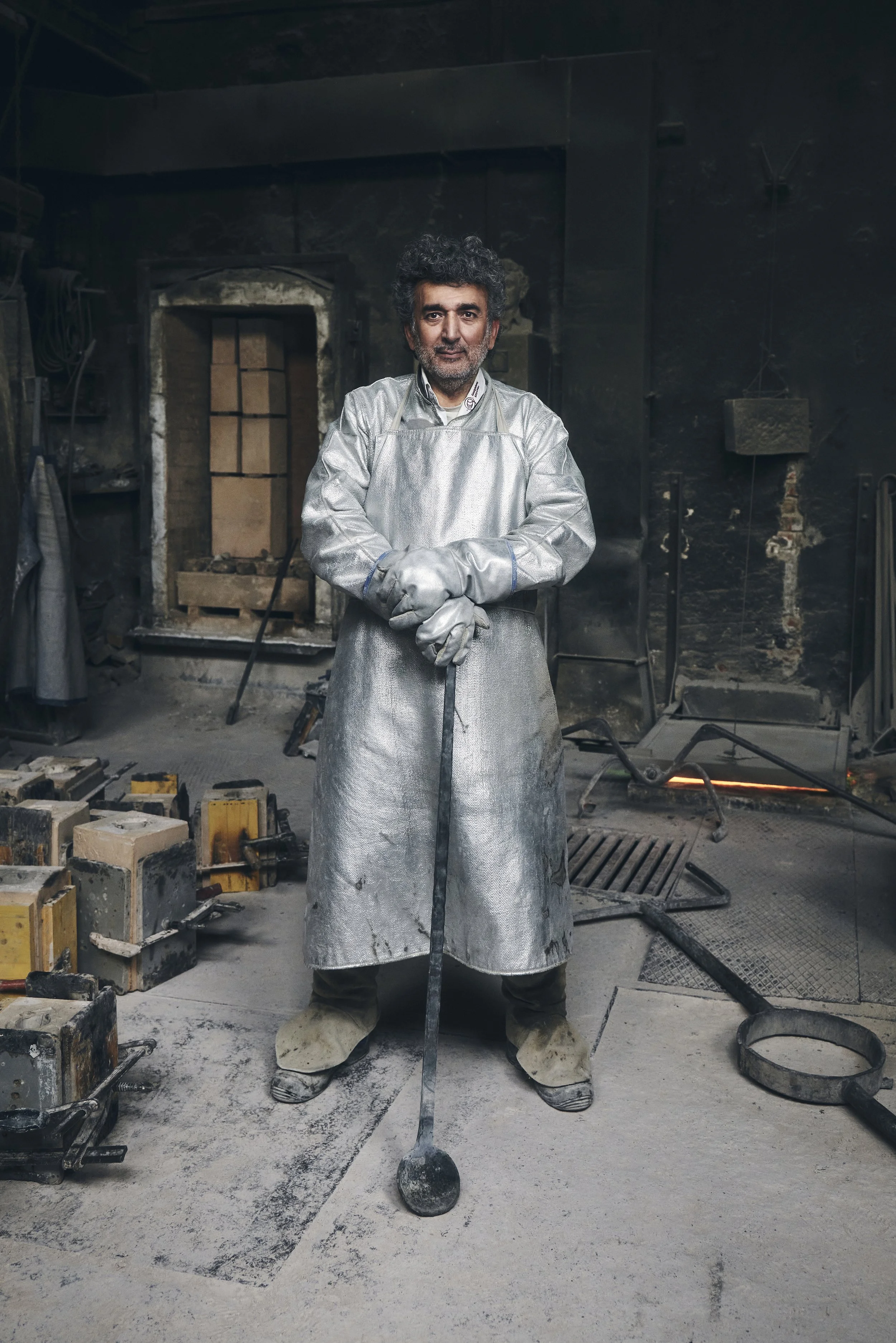 Mann in Schutzanzug mit Werkzeug in industrieller Umgebung