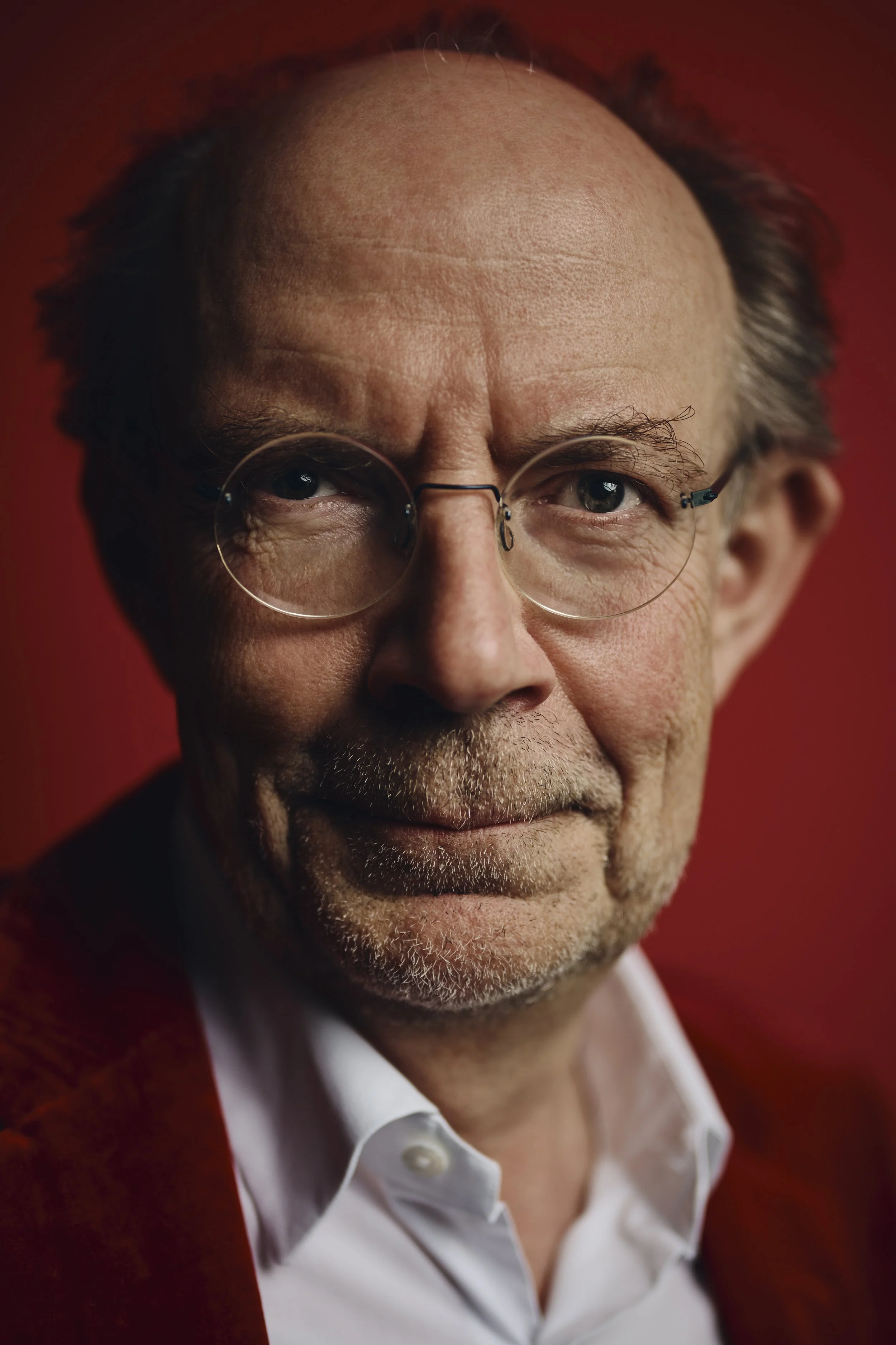 Nahaufnahme Eugen A. Russ, vor rotem Hintergrund.