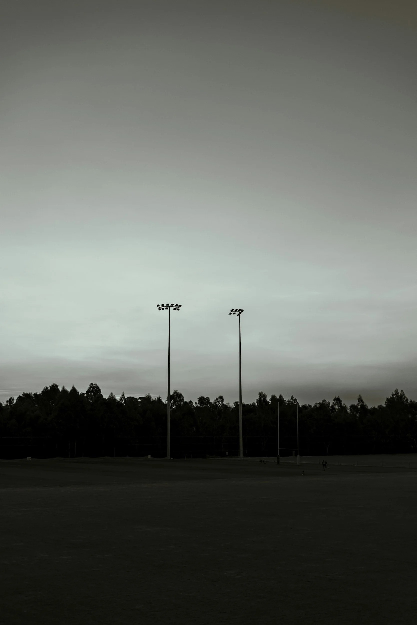 Leerer Rugbyfeld mit flutlichtmasten bei bewölktem Himmel