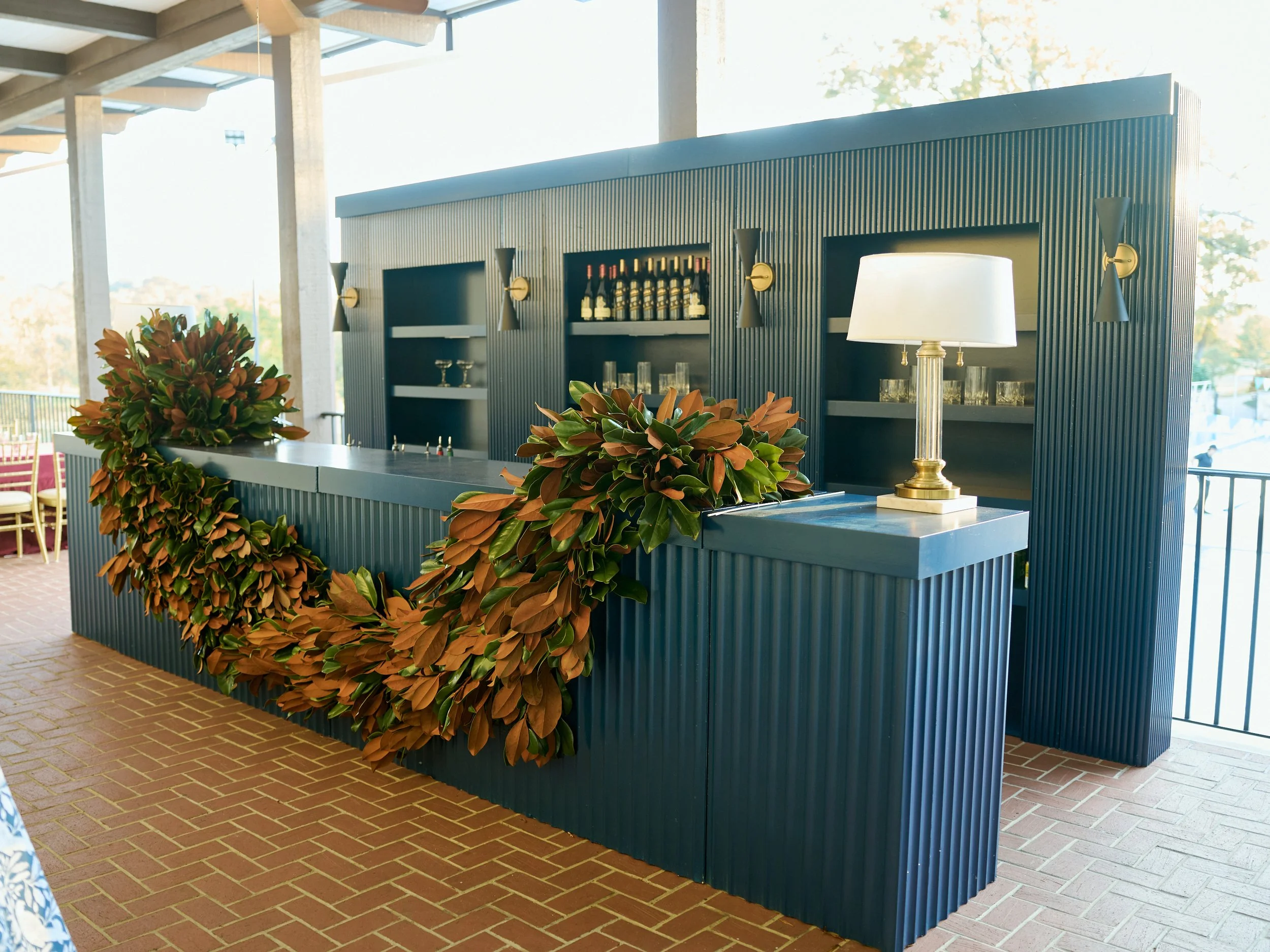 Modern boutique bar at an upscale wedding reception dressed up with a stunning magnolia leaf garland