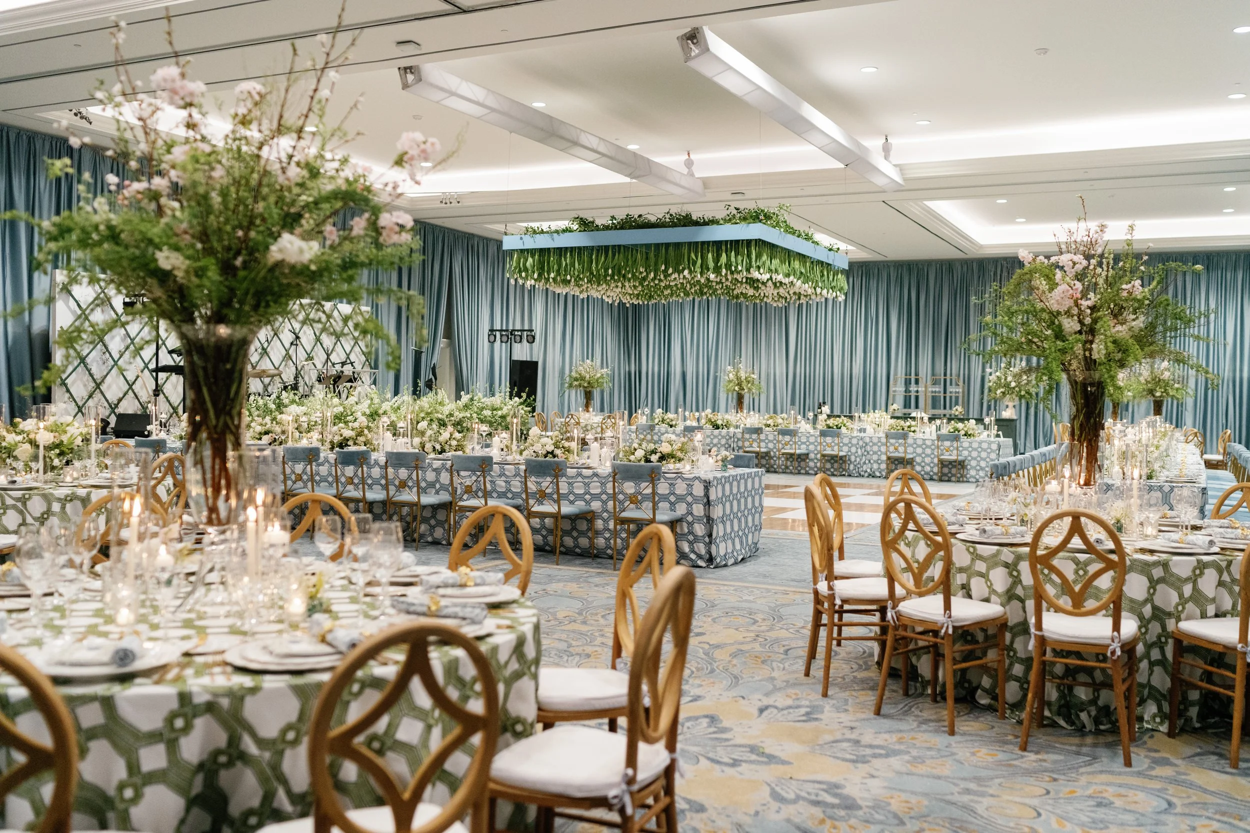 Elegant and luxurious wedding reception featuring blues and whites and massive floral table arrangements that make a statement without blocking the view of your dinner party.
