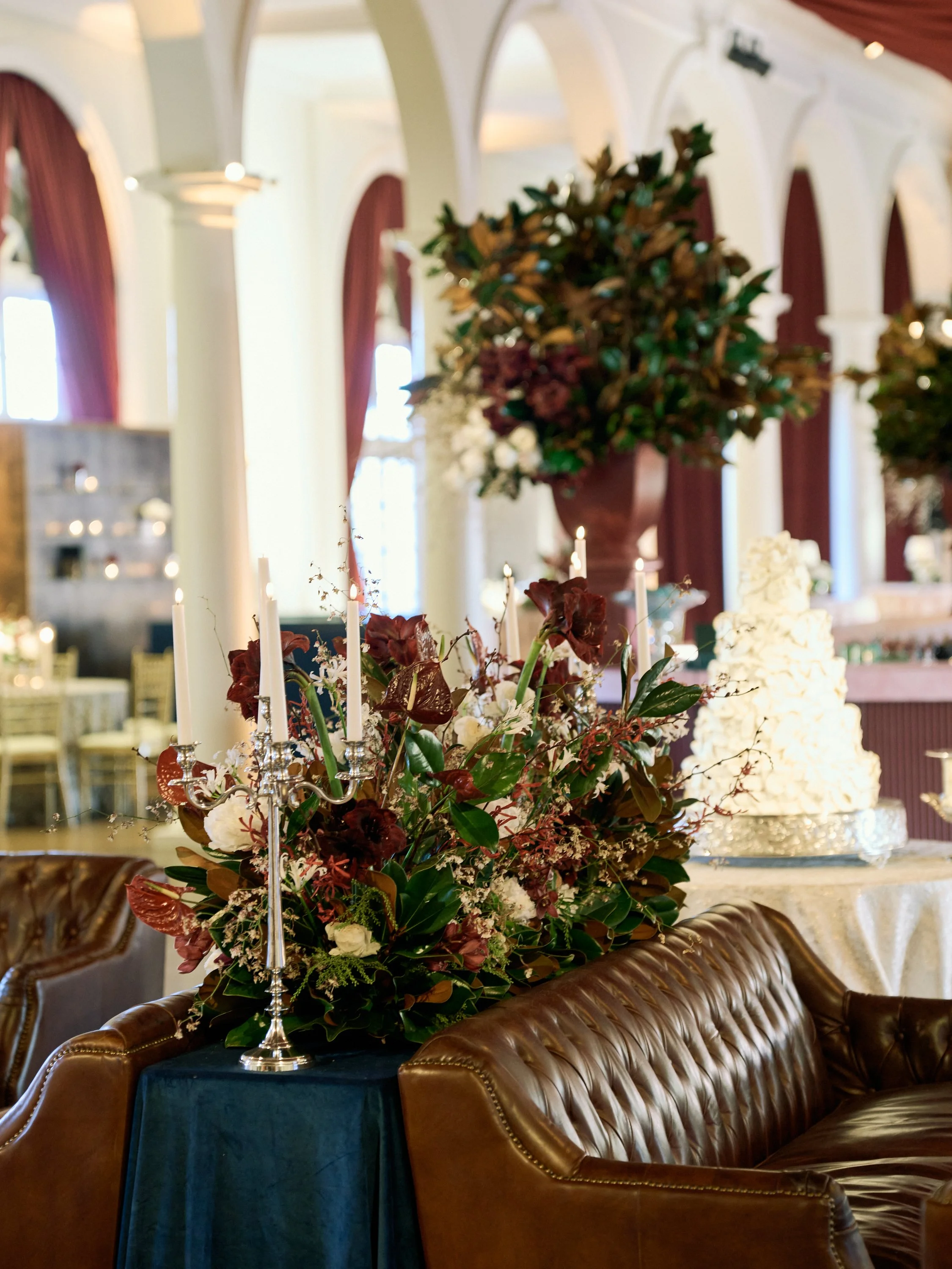 This luxurious wedding reception offered upscale lounge areas for guests, adorned with memorable floral arrangements featuring magnolia leaves