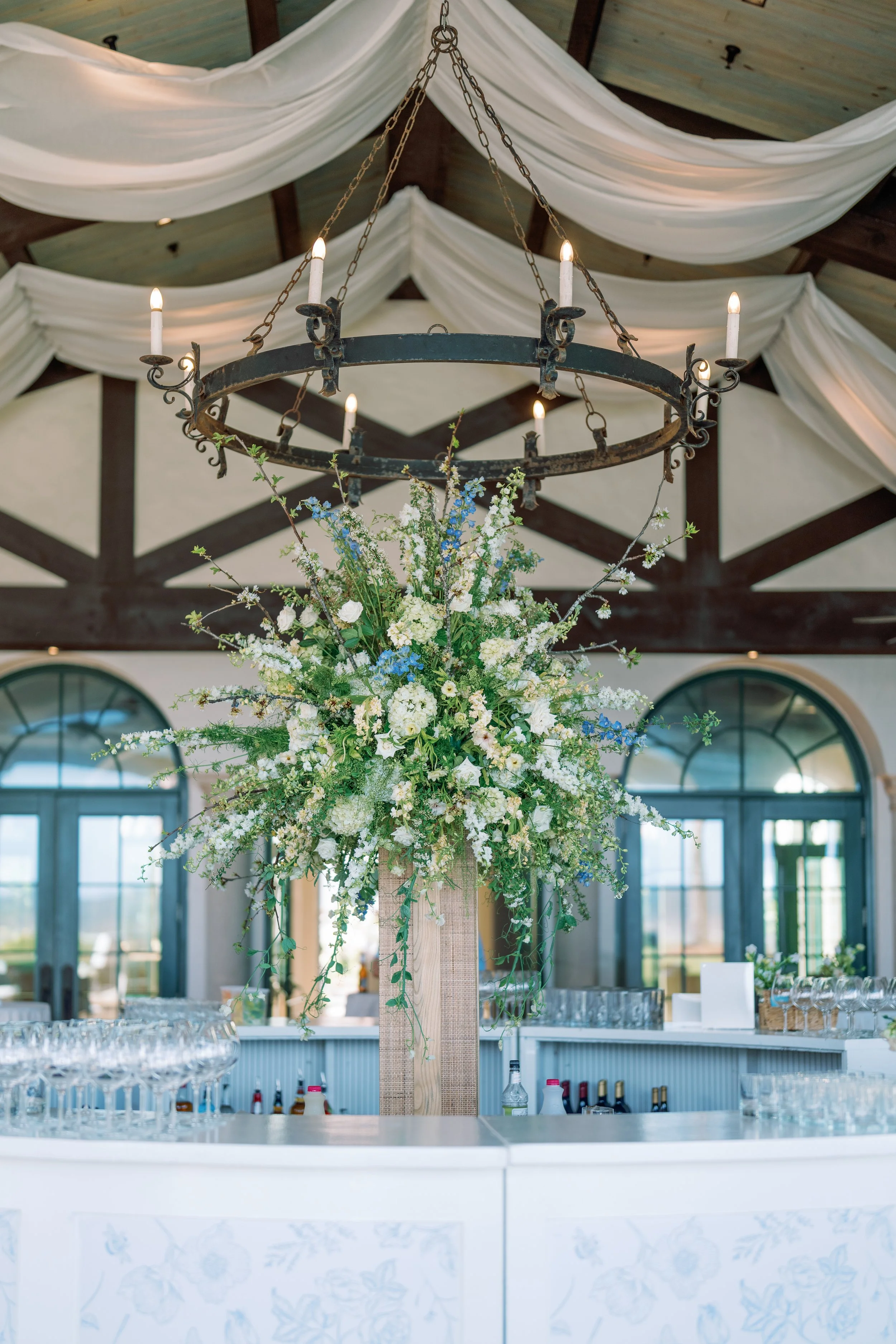 A stunning floral display sits in the middle of a circular bar that is sure to impress guests
