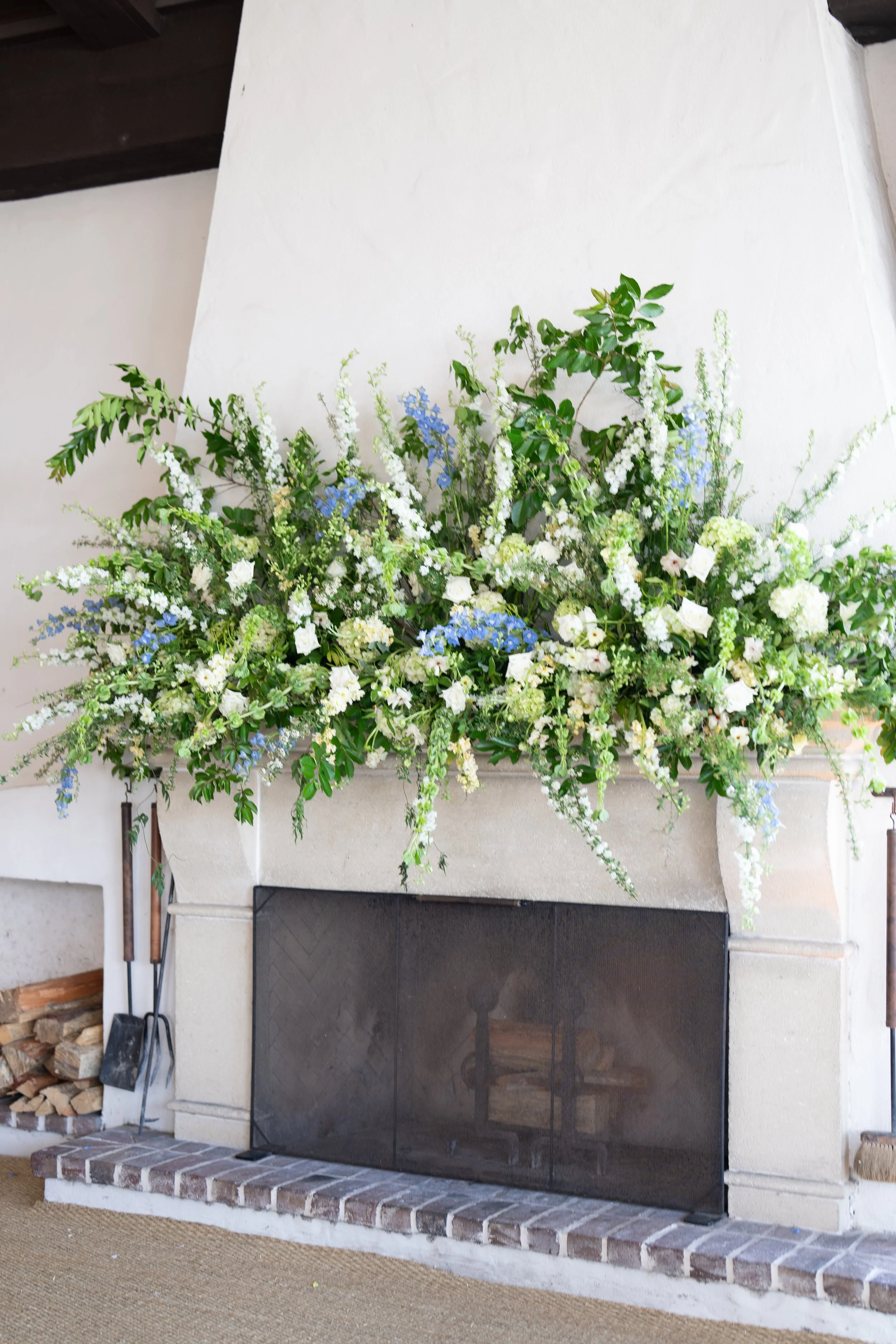 Phenomenal floral display atop a white fireplace at a Sea Island wedding reception