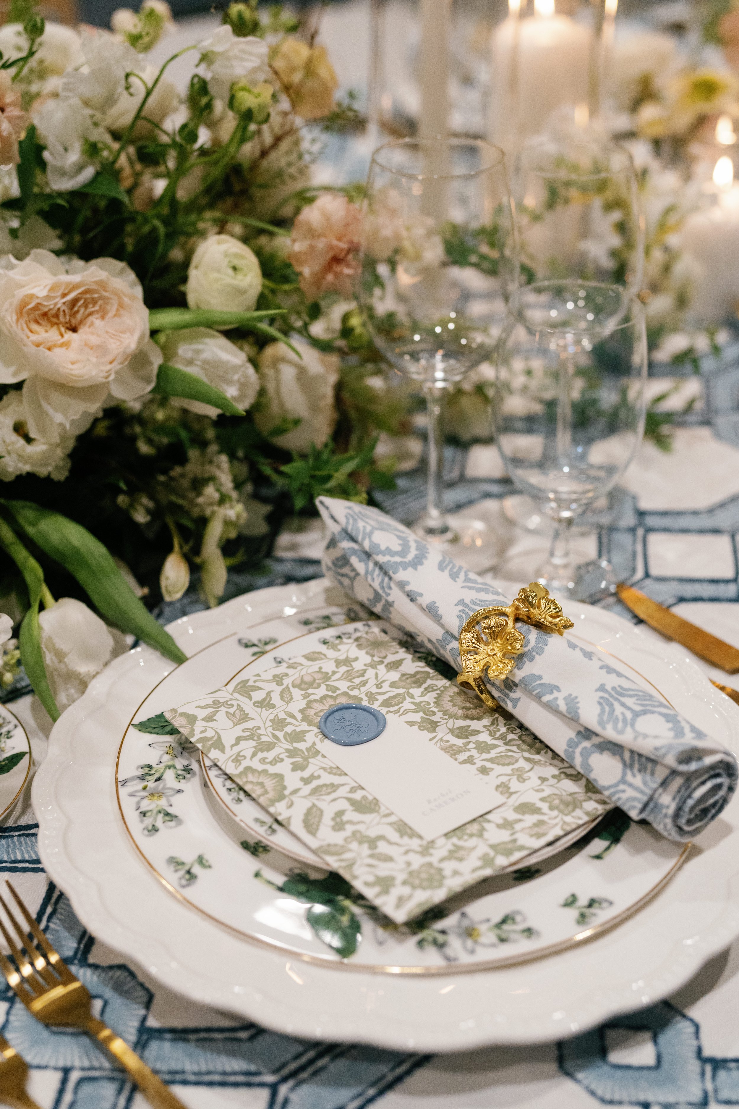 Thoughtful blue and white tablescape, beautiful table arrangement featuring china, boutique napkin and ring, and florals