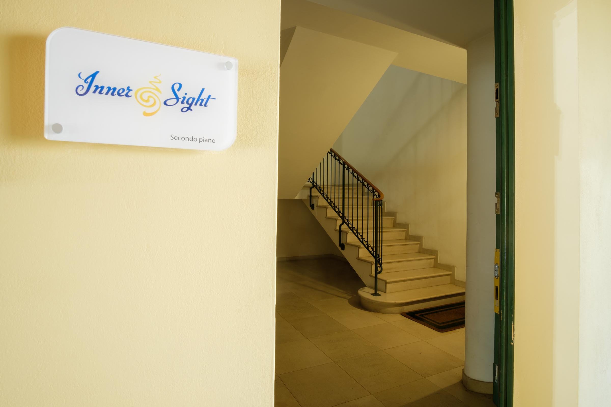 Segnale con scritta 'Inner Sight' e indicazione 'Secondo piano', vicino a un'area con scale e ingresso.