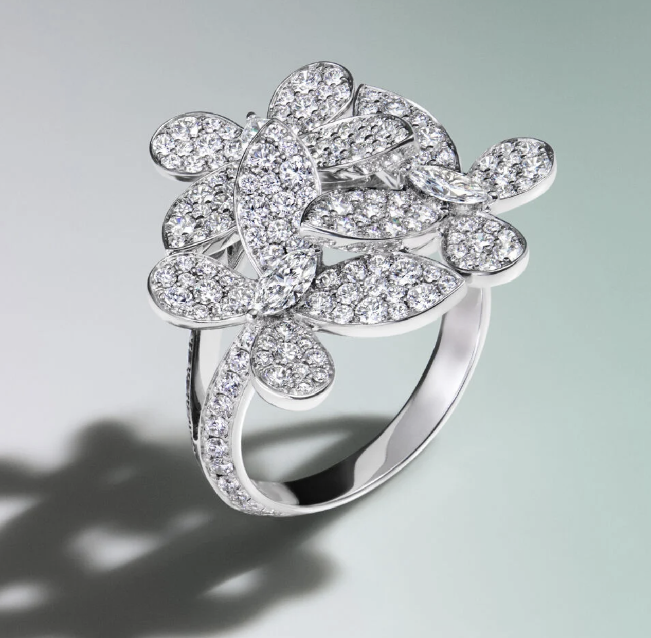 Platinum ring with a large floral design encrusted with numerous small diamonds.