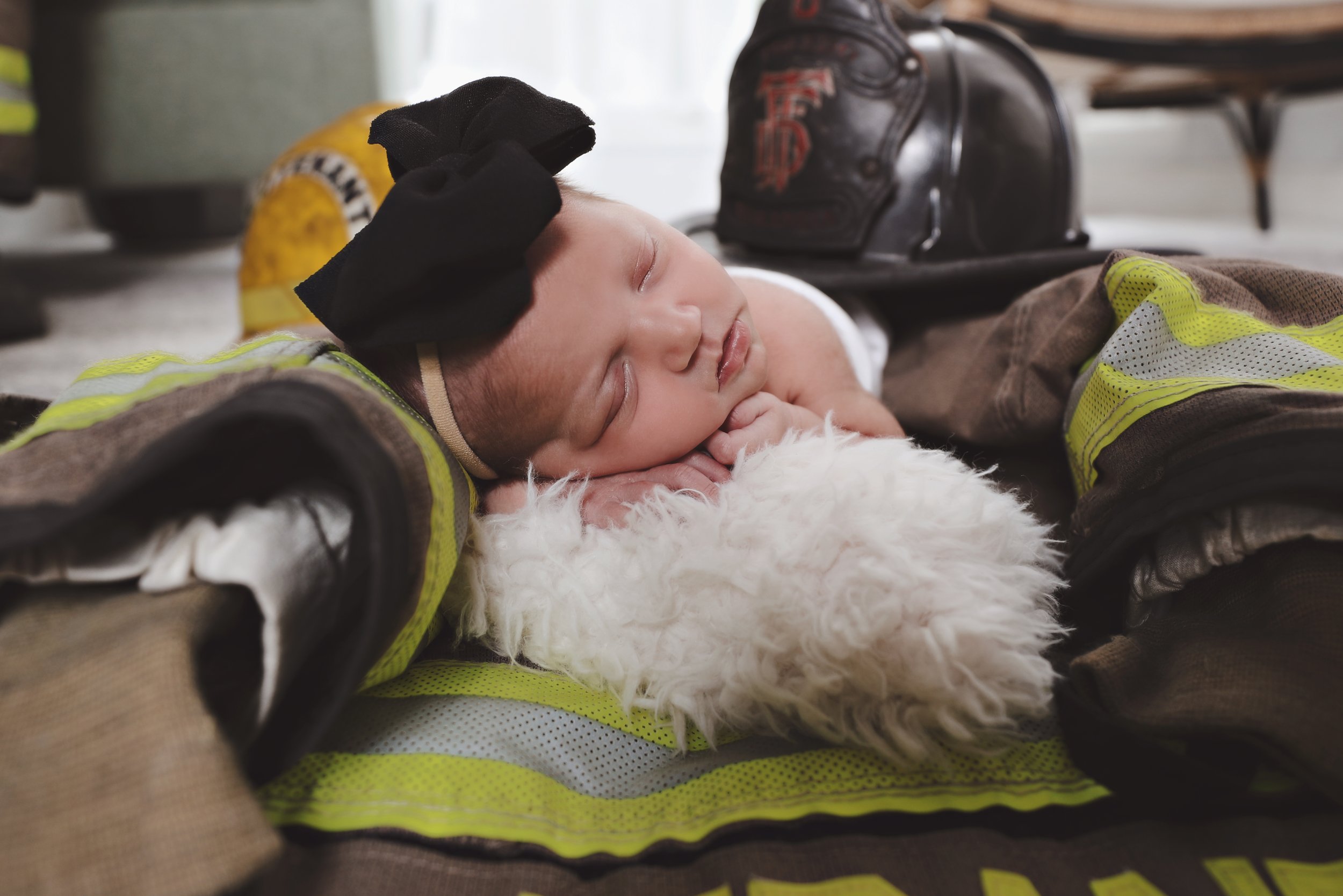 A firefighter sleeping on the ground with a white dog.