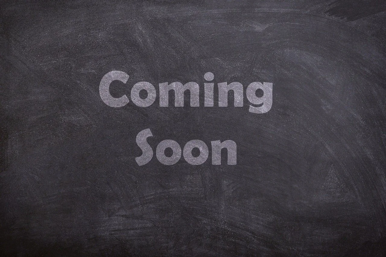 Black chalkboard with the words 'Coming Soon' written in light-colored chalk.