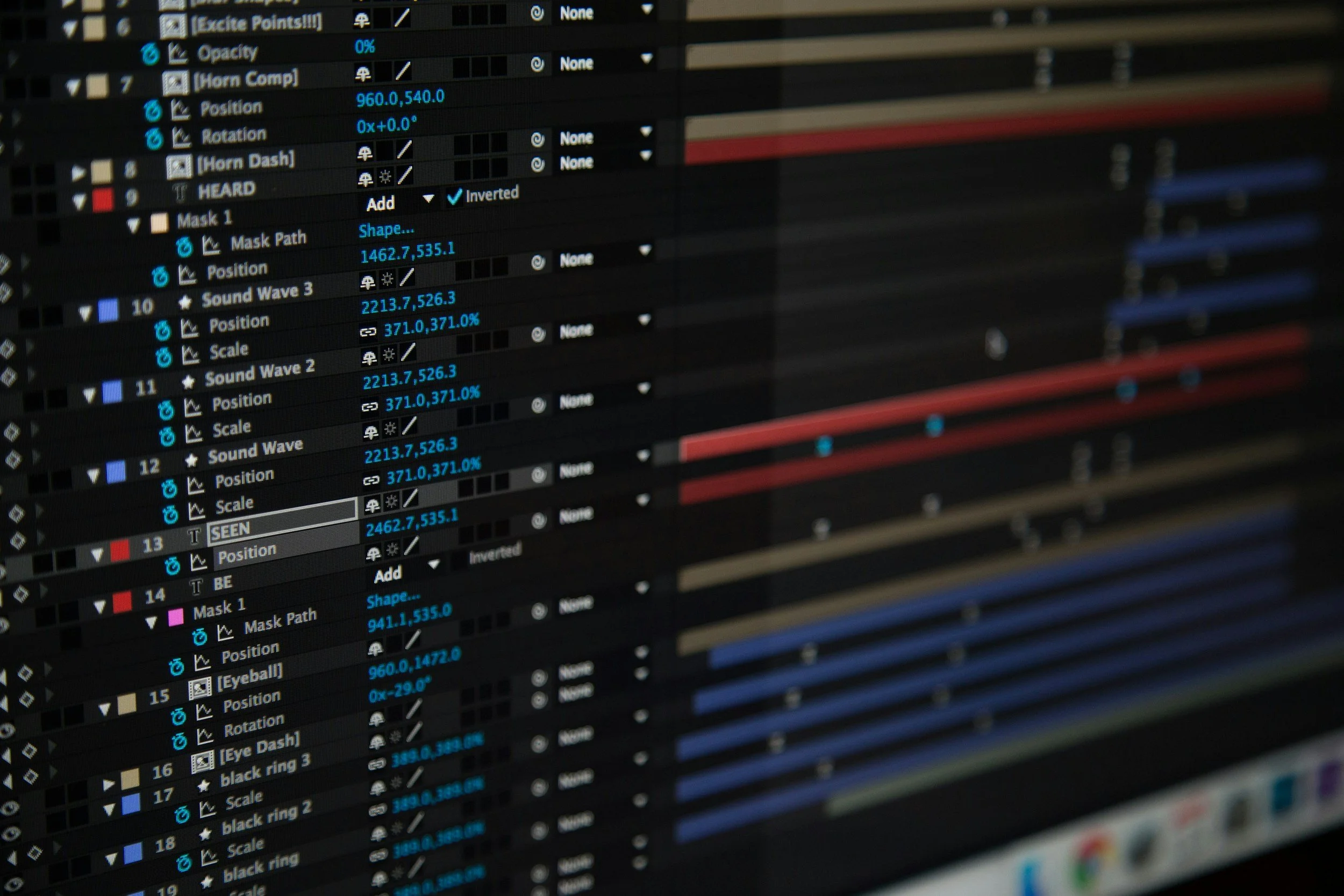 Close-up of a computer screen displaying a video editing timeline with multiple tracks, color-coded clips, and various editing controls.