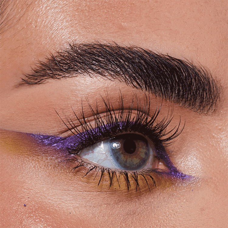 Nahaufnahme eines Auges mit Make-up, braune Iris, schwarzer Wimpernkranz, grau-brauner Augenfarbe, lila und gelber Lidschatten.